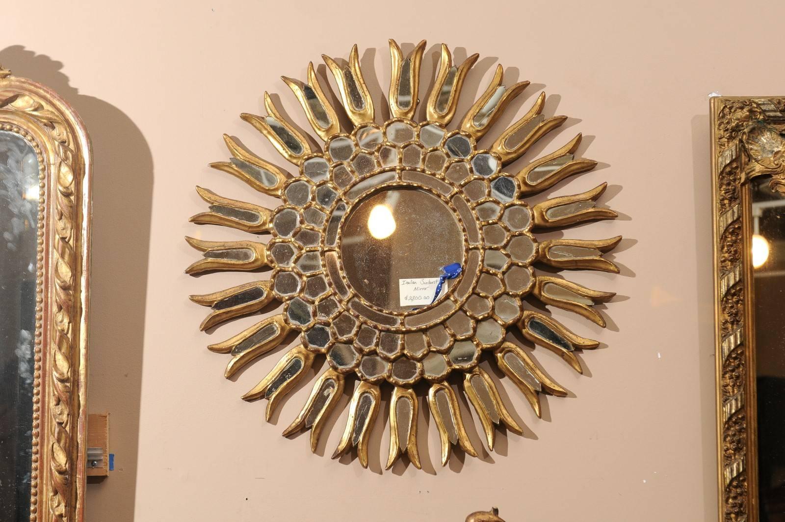 A stunning carved and gilt sunburst mirror. The piece has a great overall shape with three rows of small mirror insets surrounding the centre mirror. Sunburst mirrors Stand well alone or look great in a collection on a wall of varying shapes and