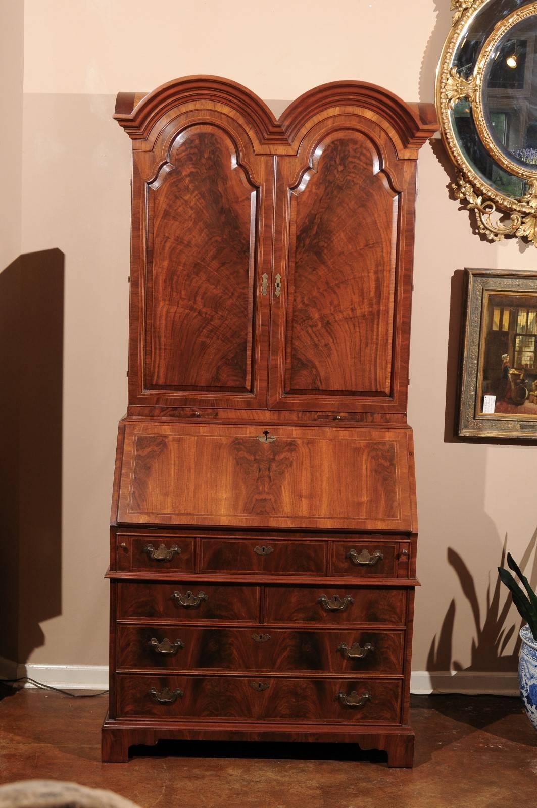 A beautiful burl walnut secretary with double domed bonnet above a pair of solid doors opening to an elaborate interior with many cubbies and drawers with satinwood trim. The lower section with slant front opens to more cubbies and drawers. Three