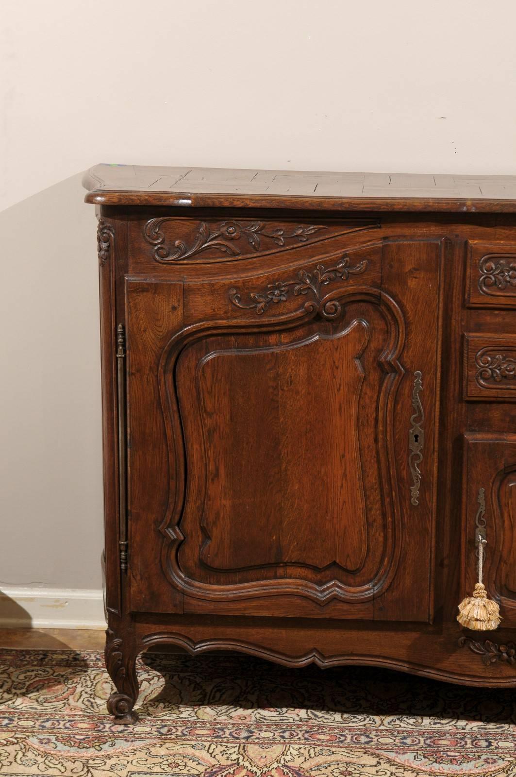 A lovely enfilade with a parquet design on the top. Two center drawers and a cabinet below. Two side cabinets have interior shelving. Carving on doors and drawers with original locks and pulls.