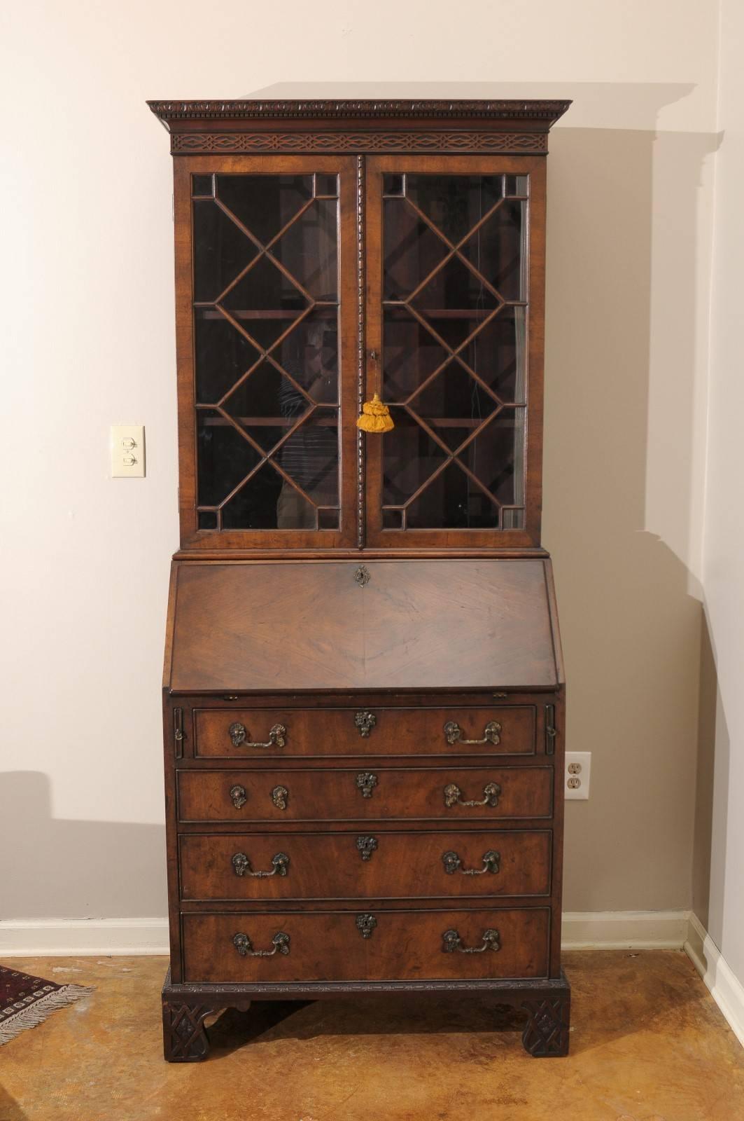 This lovely small mahogany Chippendale style secretary has beautiful fretwork and molding on the crown and on the shaped bottom and legs.
The interior has an assortment of drawers and pigeonholes. Below the slant front are two smaller drawers over
