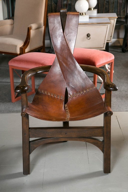 A pair of midcentury Brazilian horseshoe chairs with genuine leather slings.