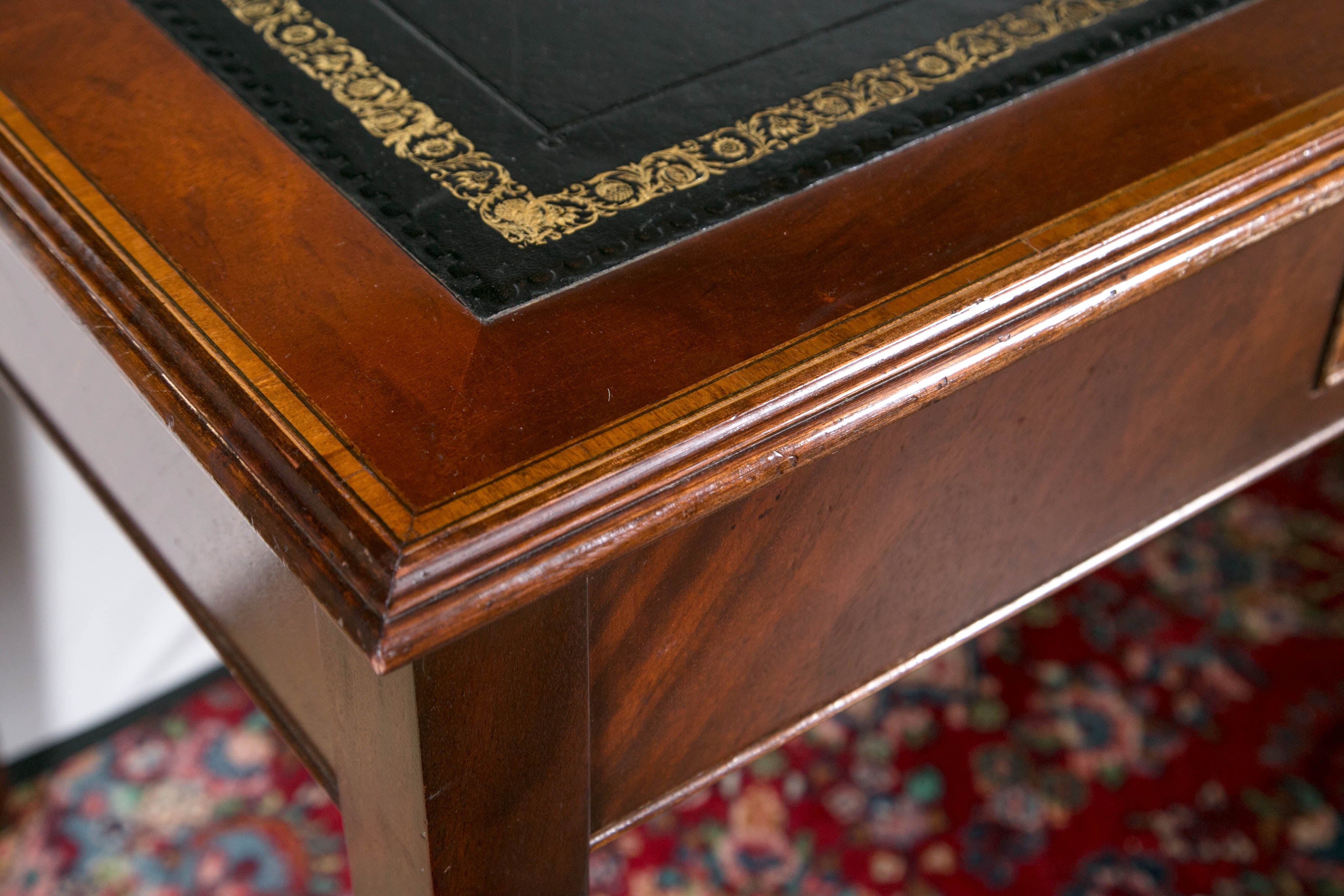 Tooled leather topped writing table. English, circa 1930. Great patina.