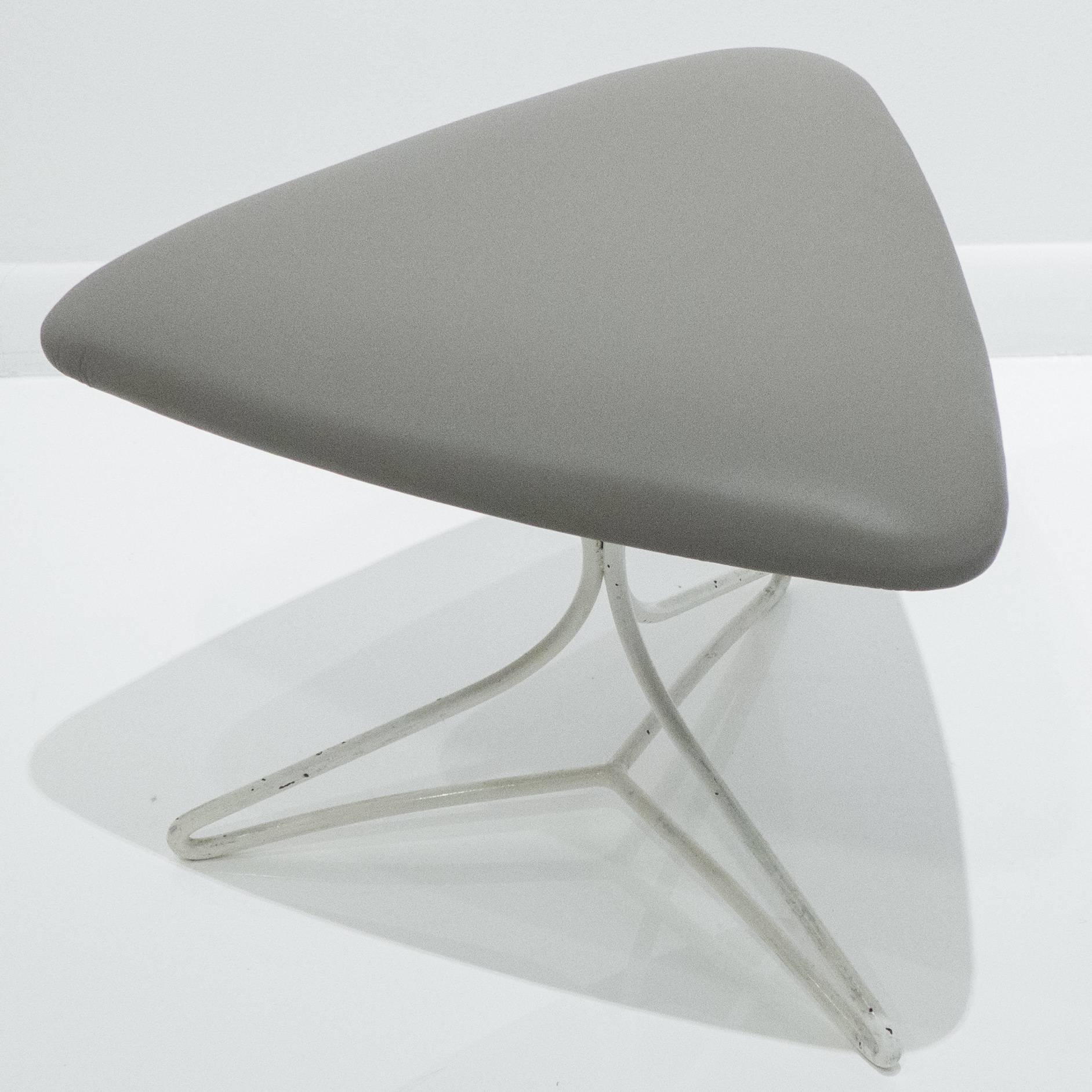 Triangular stool on tripod hairpin steel base. Designed by Vladimir Kagan and produced by Kagan Designs Inc., circa 1970s. The steel base has vintage white enamel paint; the top is newly upholstered in gray leather.
