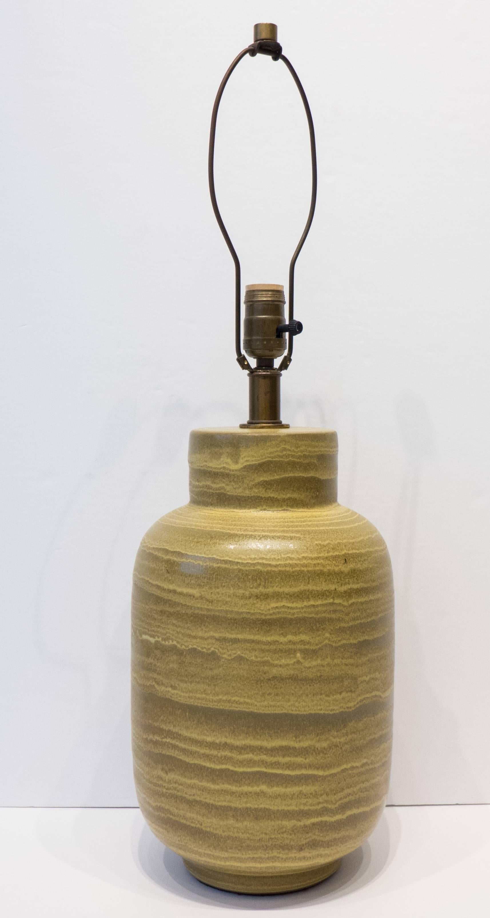 Hand-thrown stoneware lamp with a swirling matte glaze in shades of green and gold, produced by Design Technics, circa 1950s. With original brass fittings, including the finial.