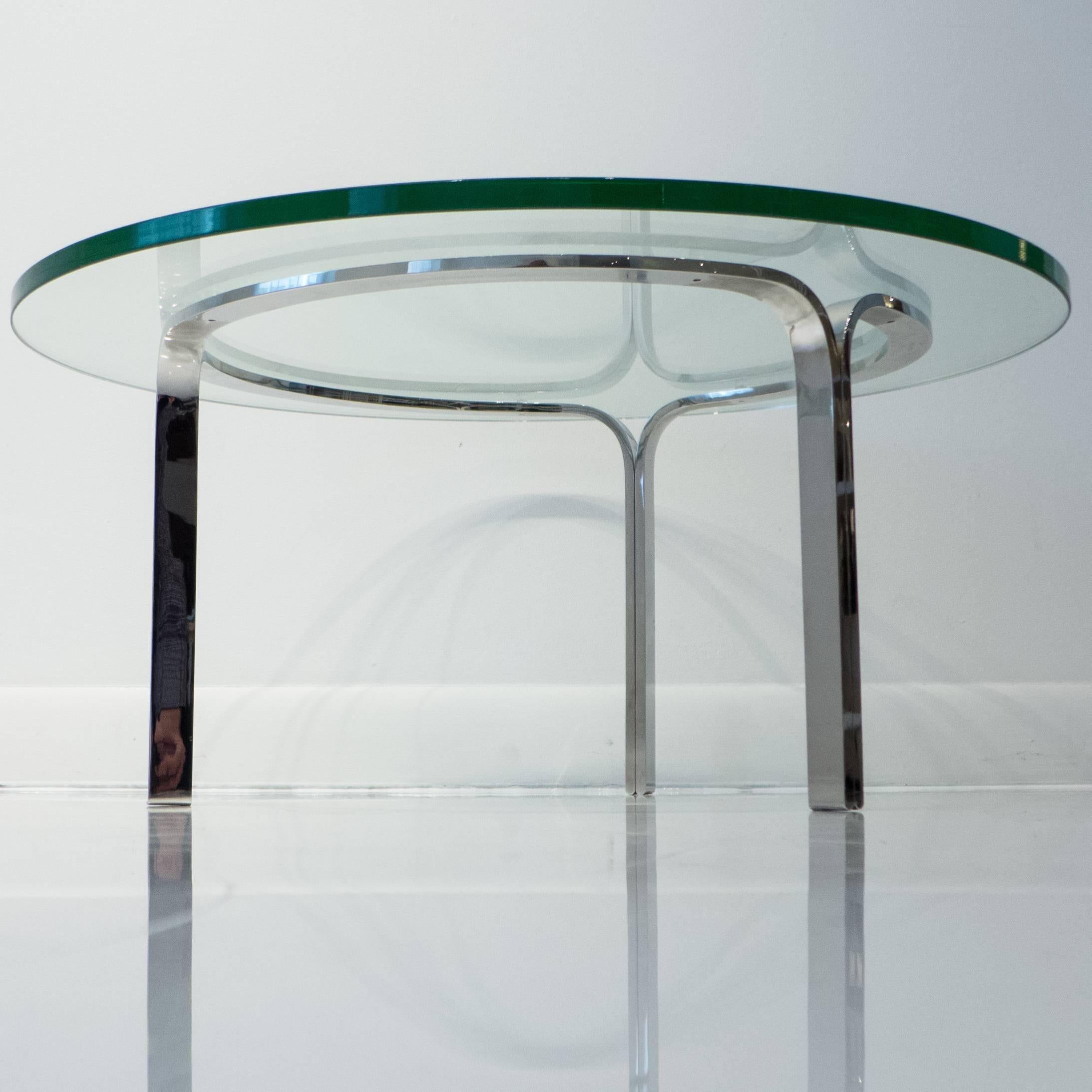 Cocktail table of polished stainless steel with a glass top. A 1960 Nicos Zographos design produced by Zographos Designs, Ltd, circa 2010. In excellent condition, with stamped mark underneath.