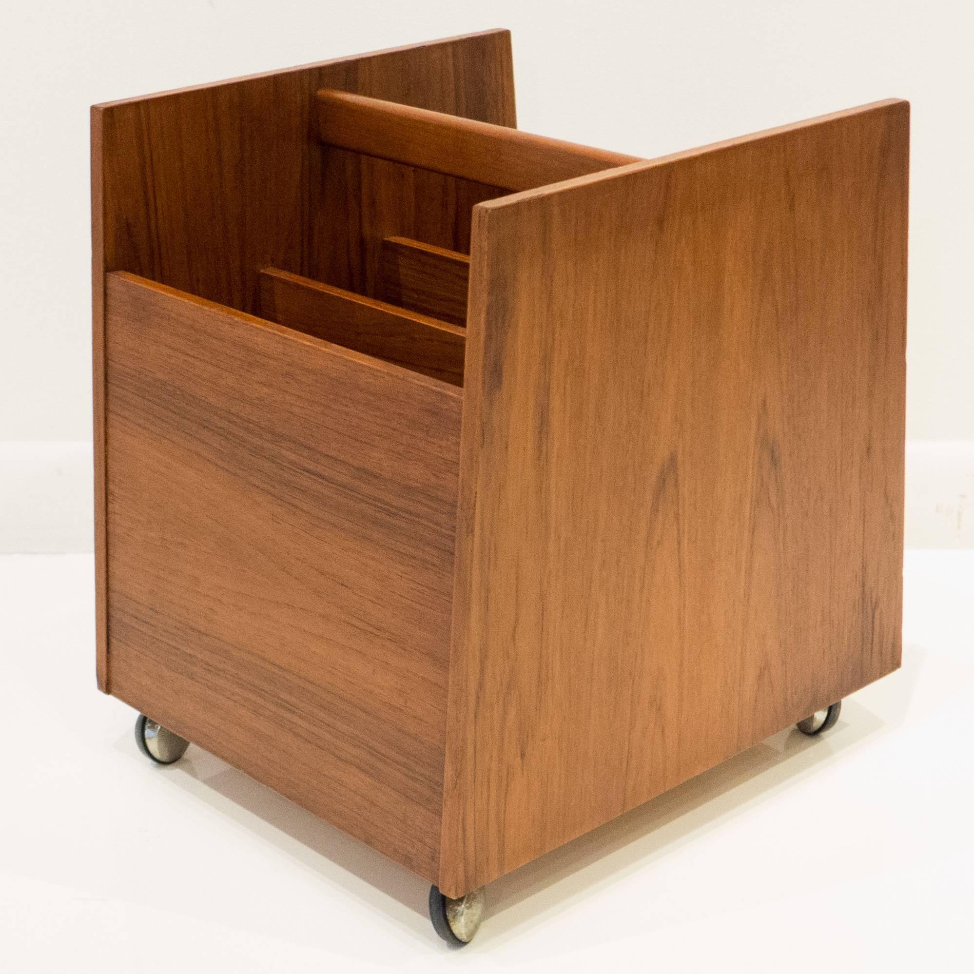 Teak-veneered magazine or record bin with vertical dividers, on casters. Designed by Rolf Hesland for Bruksbo, Norway, circa 1960s. Retains original label. The dividers slide out for larger loads.