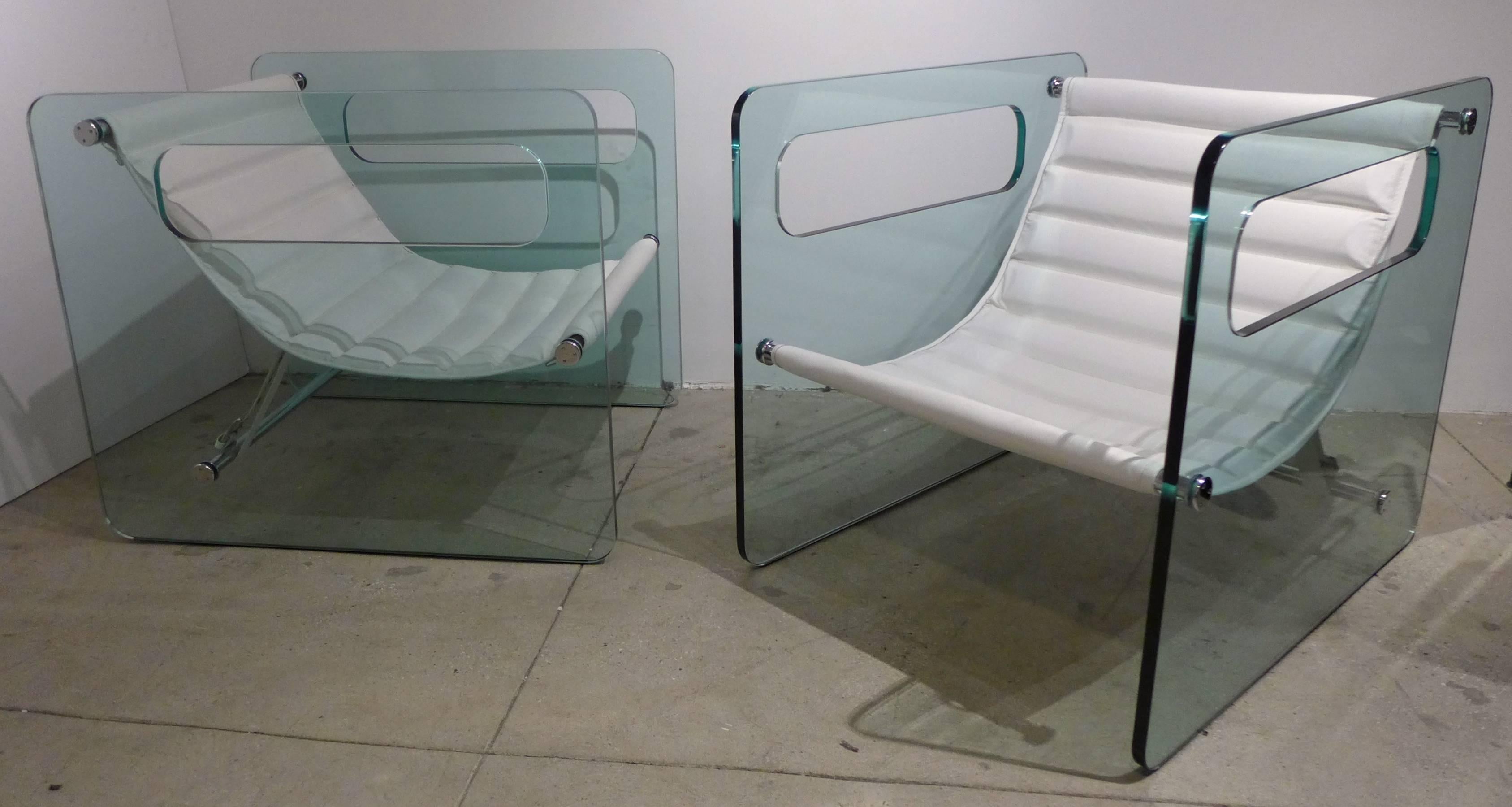 Pair of lounge chairs with three-quarter inch plate glass sides, chrome-plated steel supports and channeled leather slings. A 2002 design by Italian architect, graphic designer and furniture designer Giovanni Tommaso Garattoni. A chic and sleek