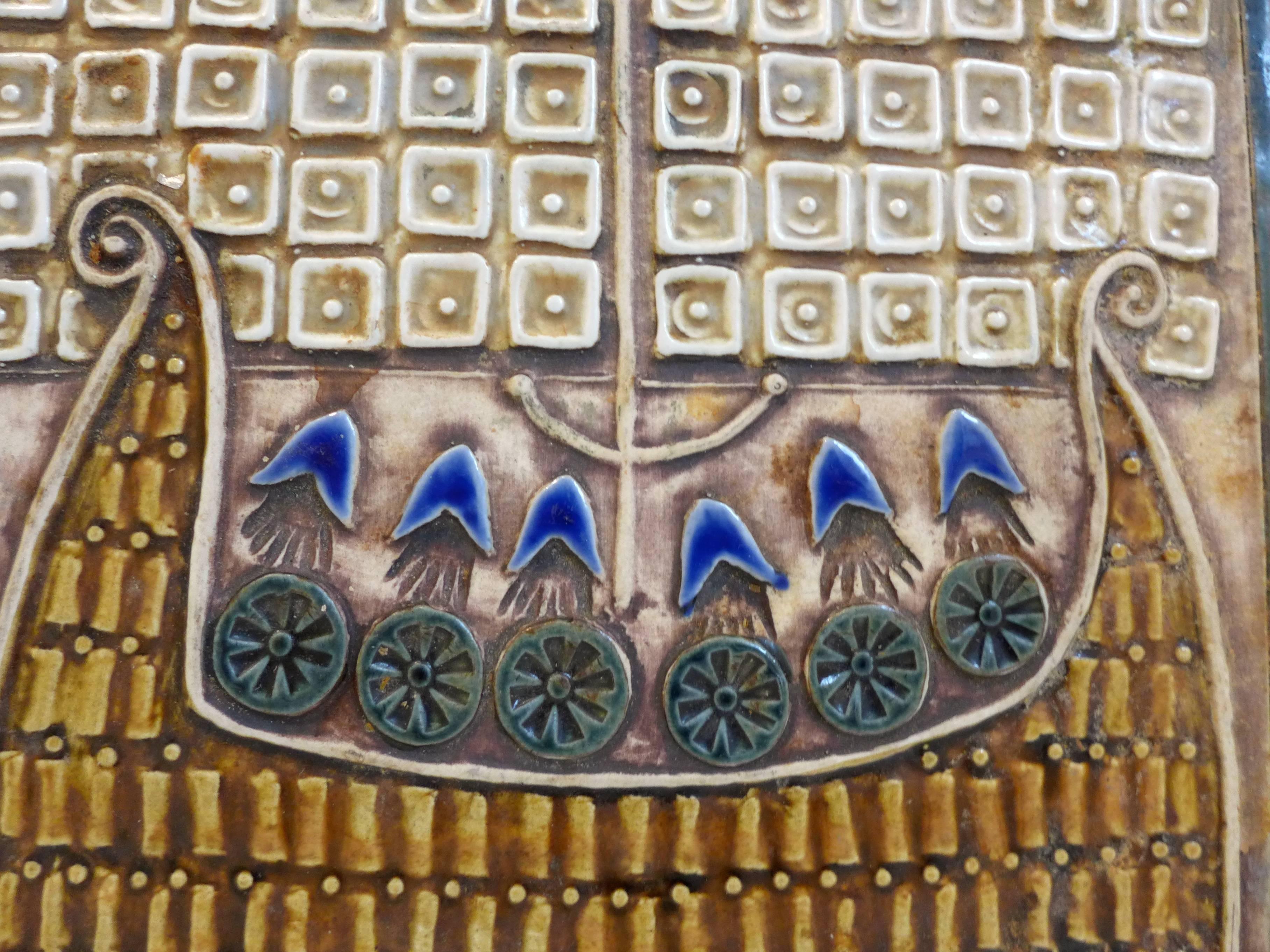 Glazed stoneware relief tile with a Viking ship motif, by Swedish ceramist Lisa Larson.  Made at Gustavsberg, c. 1960's.  Signed Lisa L on the front lower right; paper Gustavsberg stamps on the back.  Fitted to hang on a wall.
