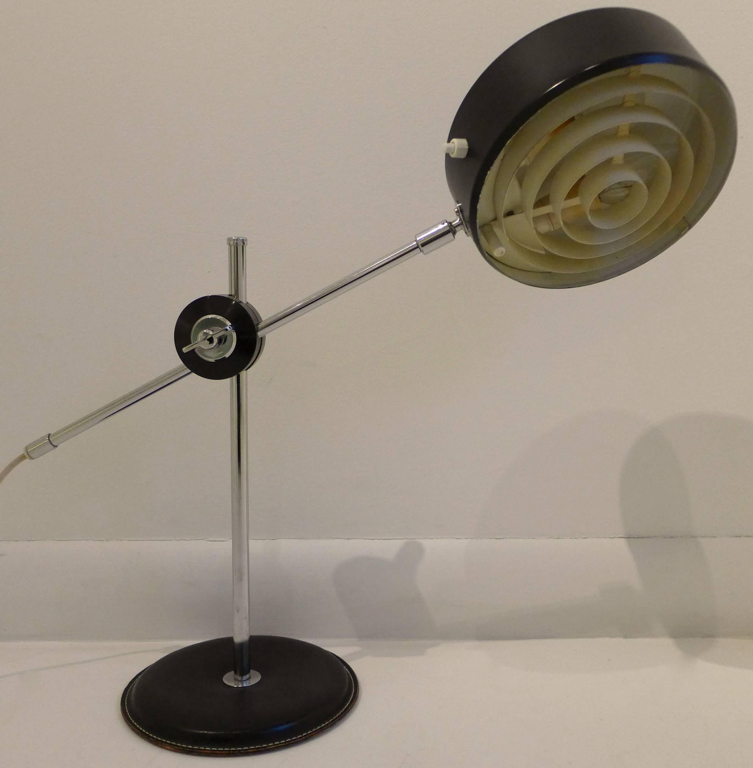 Adjustable desk lamp of polished chrome and enameled aluminum, with a leather clad base. Designed by Anders Pehrson for Ateljé Lyktan, produced circa 1960s. In fine original condition.