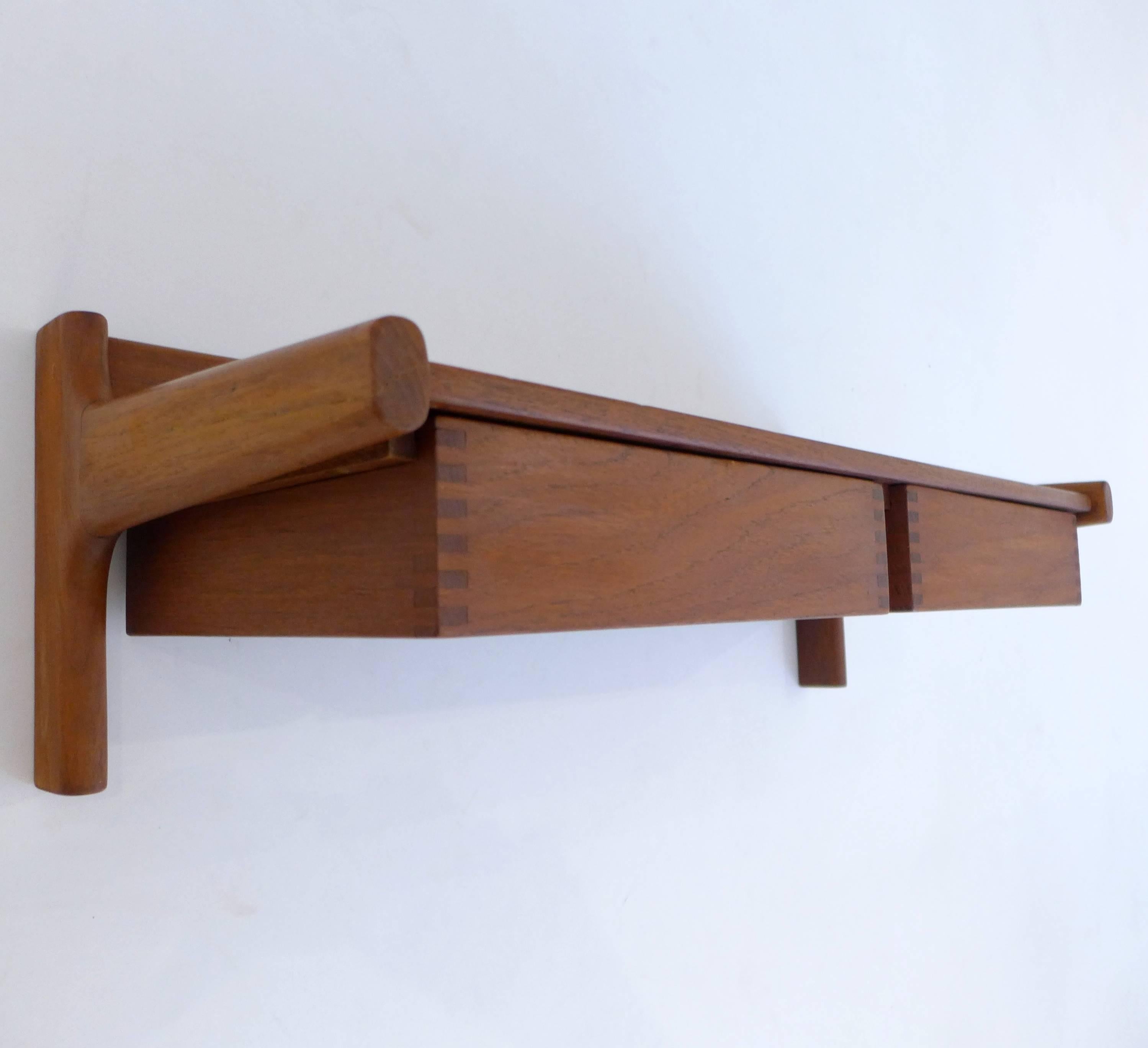 Two-drawer hanging shelf or cabinet of teak with dovetail joint details and finger pulls on the floating drawers. Designed by Borge Mogensen and made by Drylund, Denmark, circa 1960s. With original paper label.