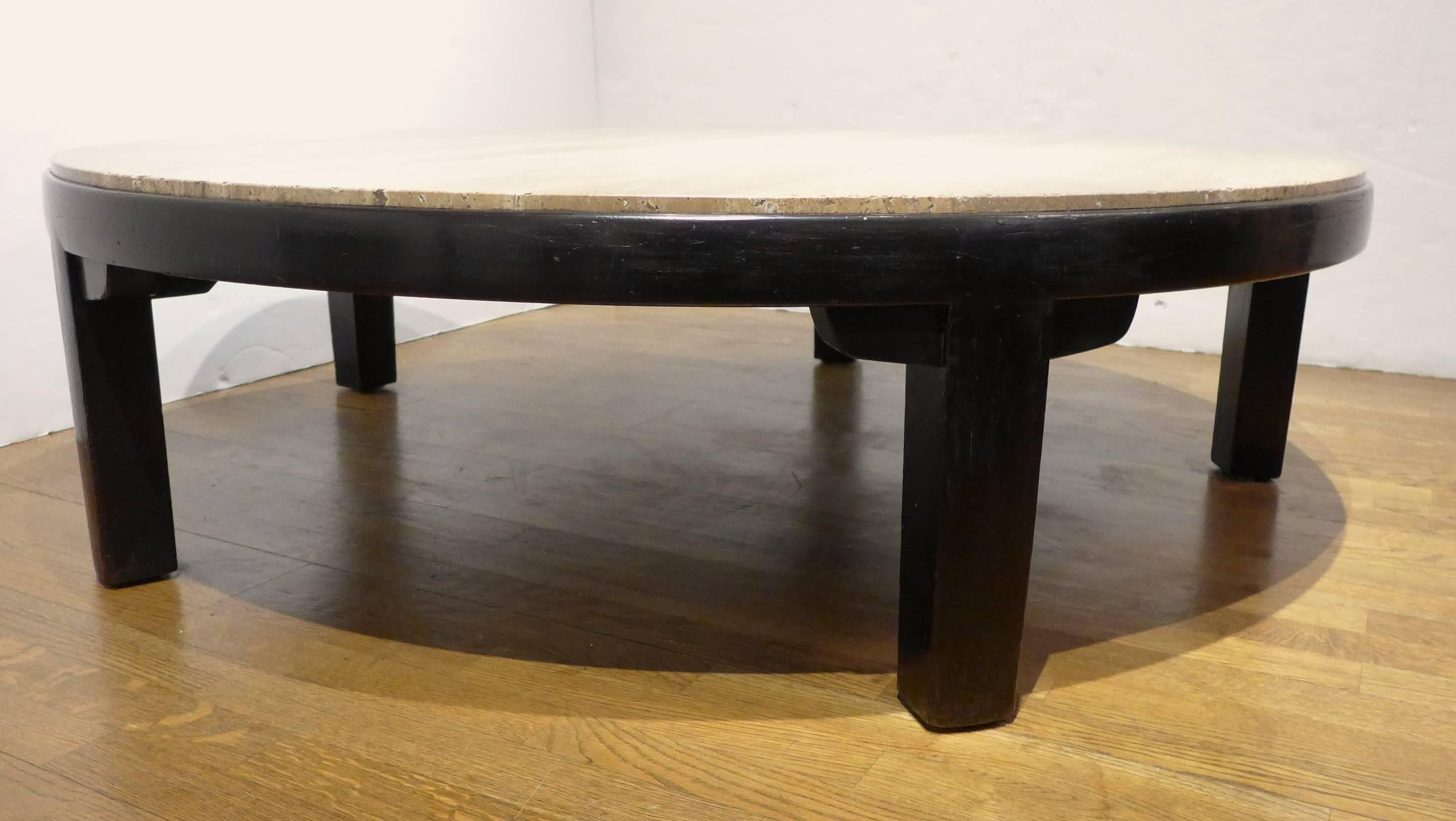 Large round cocktail table with dark mahogany base and figured travertine marble top in shades of tan, brown and gray. A clean, Asian-inflected modern form designed by Edward Wormley for Dunbar Furniture and produced, circa 1960. The base has been