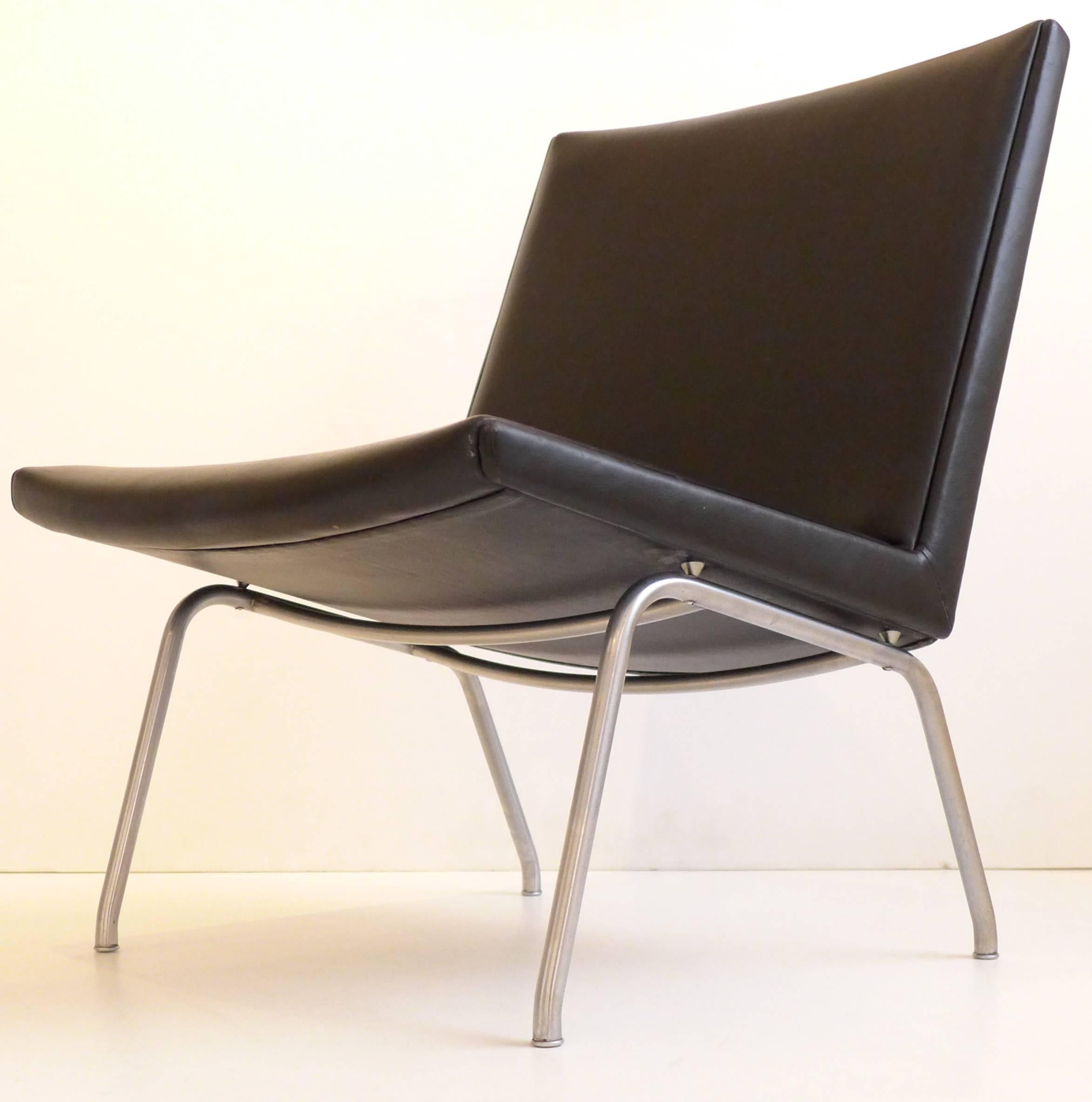 Sleek easy chair in chrome-plated steel and leather. Designed by Hans Wegner for the Kastrup Airport in Copenhagen and produced by A.P. Stolen from 1959-c. 1980. This is a vintage example in fine original condition, with only minor wear to the steel