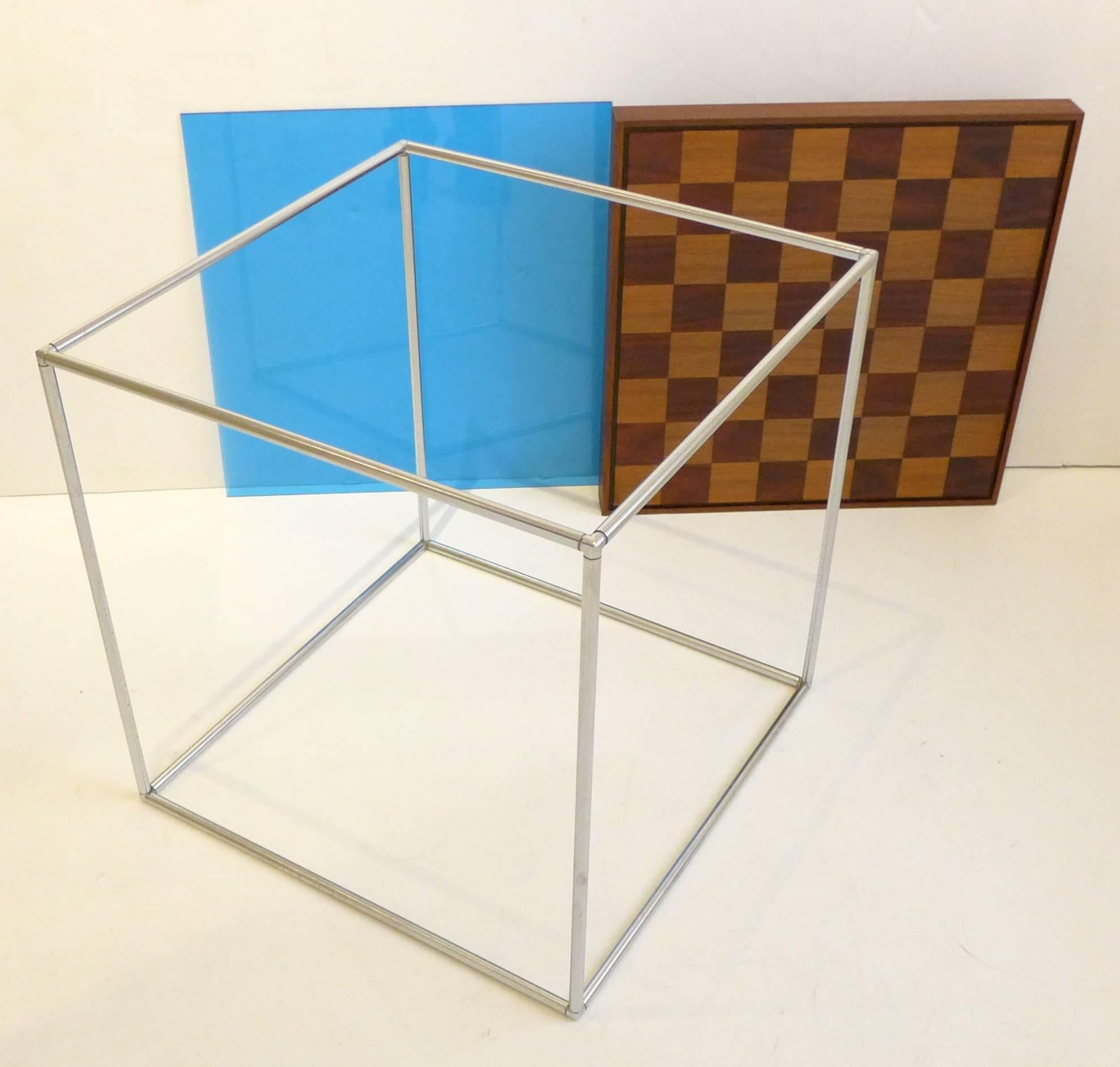 Chessboard in two-tone walnut with dovetailed edges and blue-tinted acrylic panel, sitting atop its cubic tubular chrome base. Designed by Austin Cox to accompany the celebrated aluminum chess set he designed as part of ALCOA’s, early 1960s Campaign