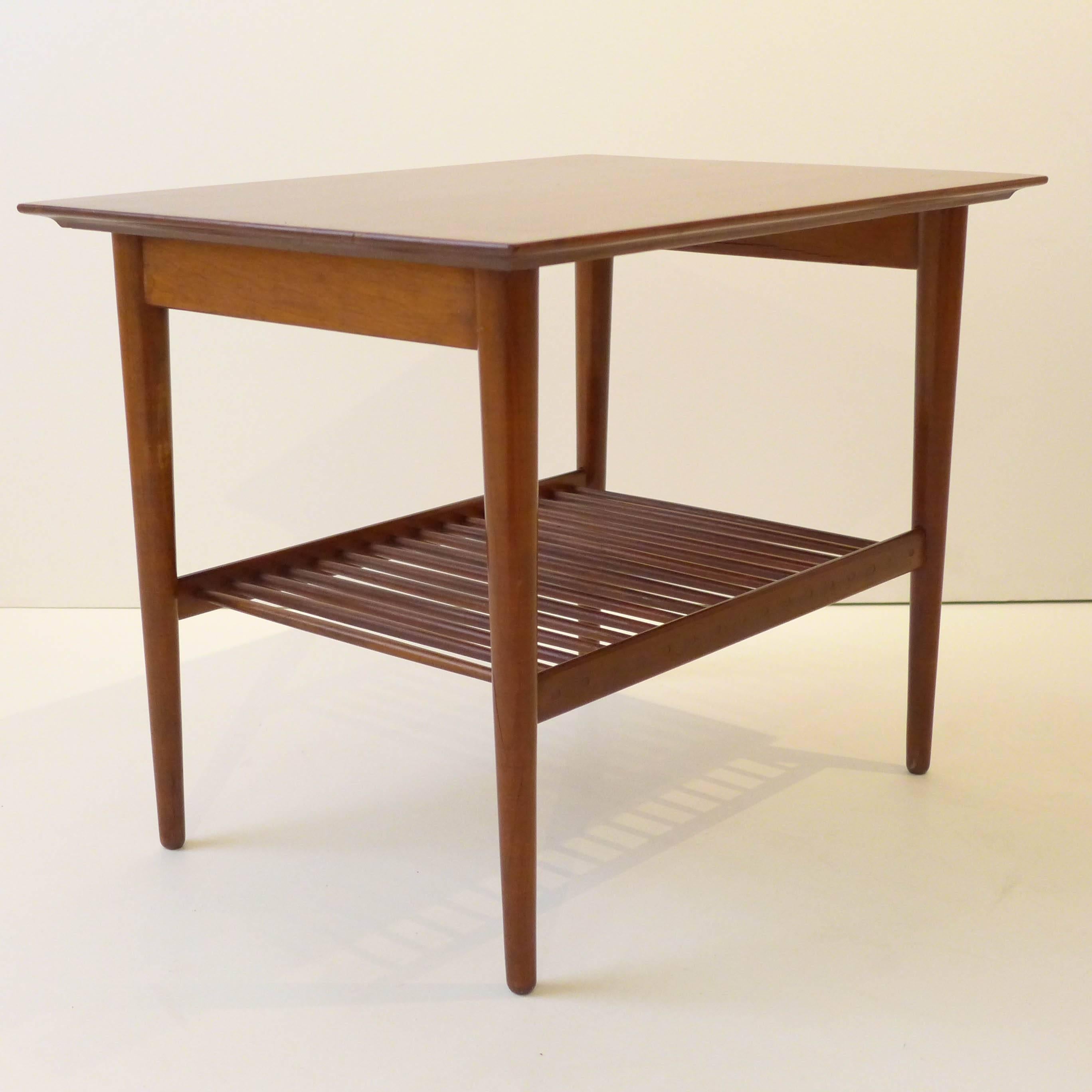 Walnut side table with tapering legs and an open medial shelf consisting of a series of dowels. Nice details throughout. Designed by Kipp Stewart and Stewart MacDougall as part of their American Design Foundation line and produced by both Calvin and