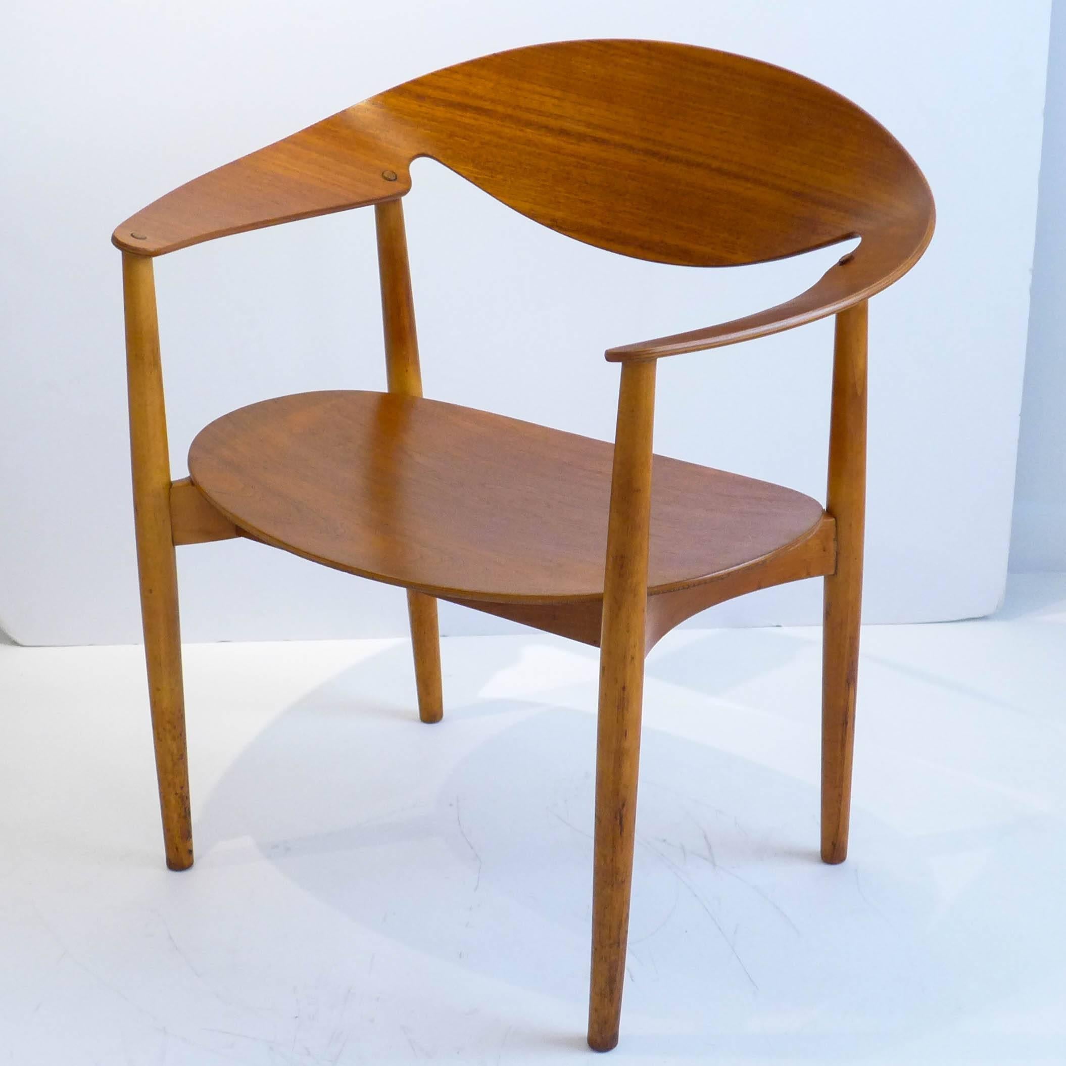 Early and rare metropolitan chair of teak plywood and lathe-turned beech. Designed by Aksel Bender Madsen and Ejner Larsen and produced by Fritz Hansen, circa 1950s. In quite good vintage condition with original wooden plugs covering the screw holes