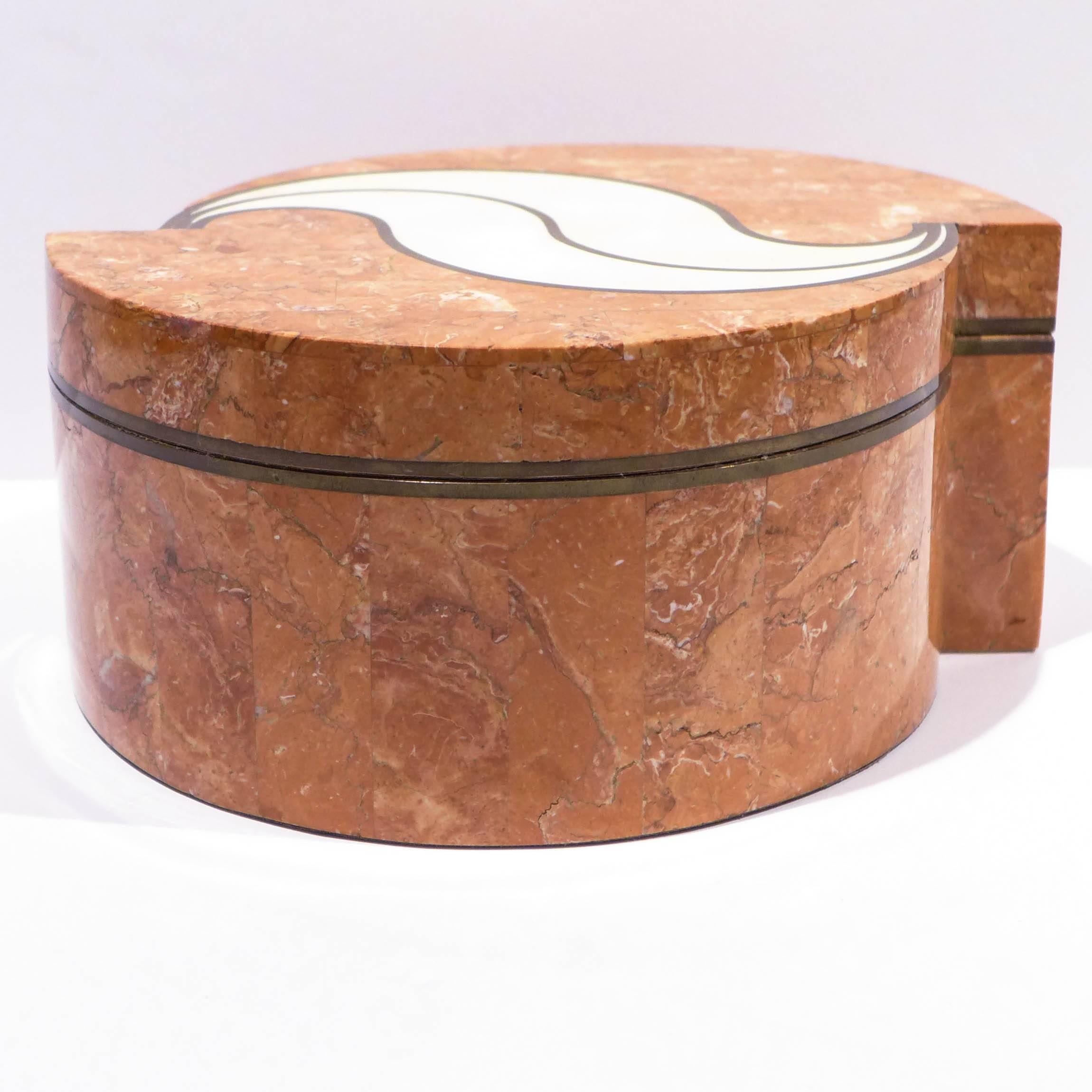 Tessellated stone box with brass trim and eccentric, offset demilune shape and stylized decorative motif. Velvet-lined interior and bottom. Made by Maitland-Smith, circa 1980s.