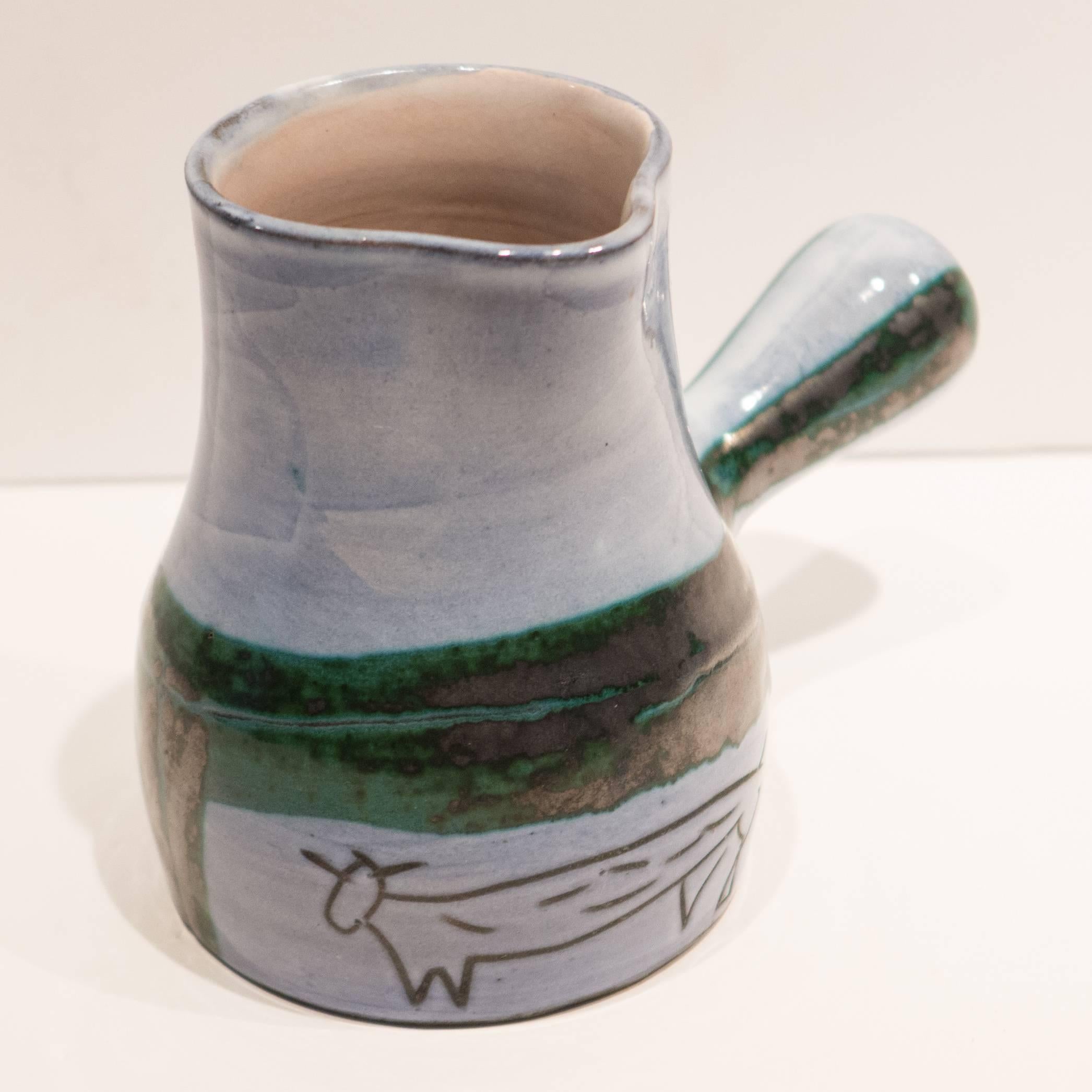 Small glazed earthenware milk pitcher or creamer with handle and incised abstract bovine images, by renowned Vallauris ceramic artist Jacques Innocenti (1926-1958). Signature to bottom.