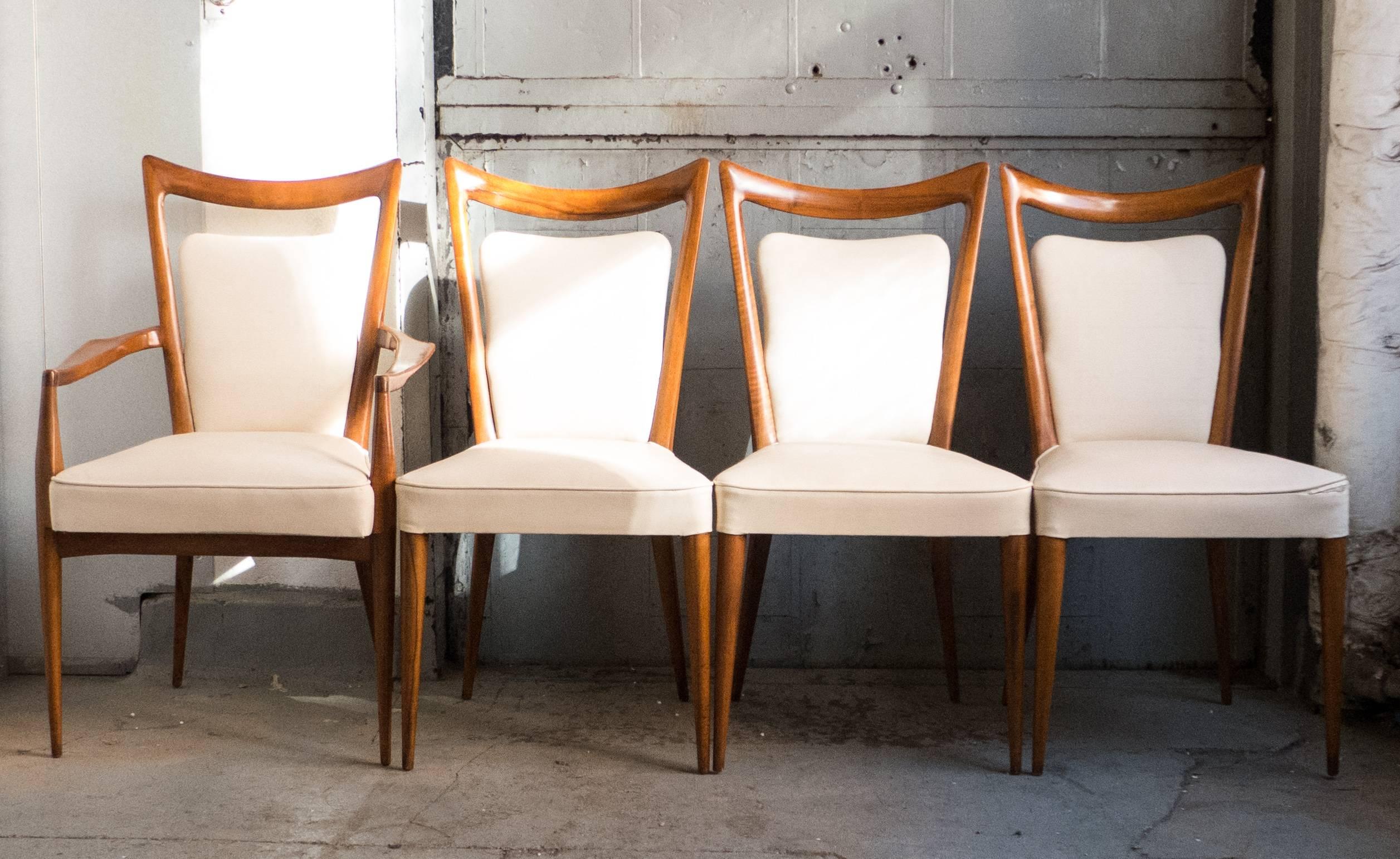 Set of eight sculptural chairs in walnut--two armchairs and six side chairs--by the Milanese architect Melchiorre Bega. Imported to New York by Erno Fabry, circa 1950s. In fine estate condition; the wood has been cleaned and polished, the joints are