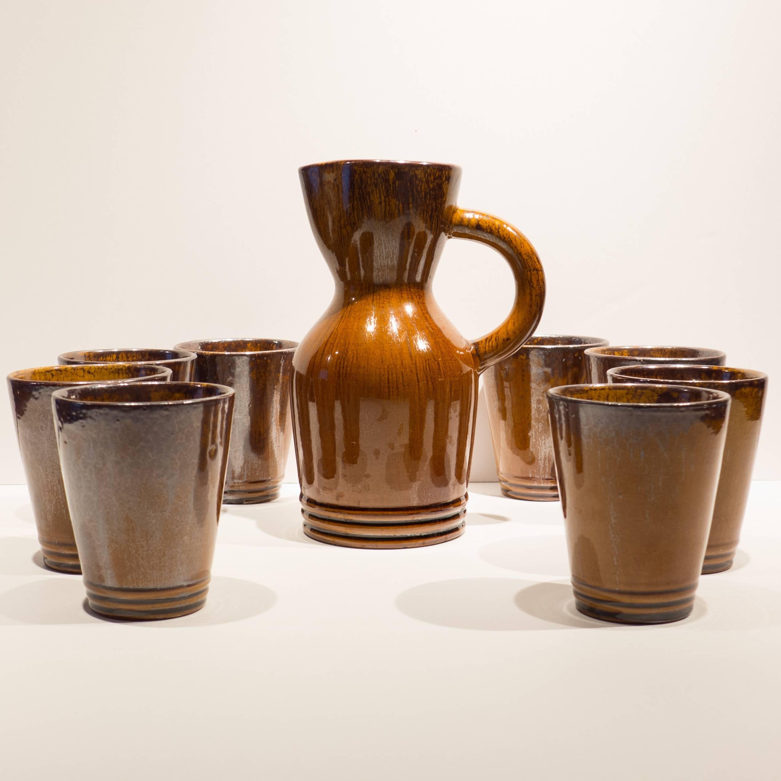 Hand-thrown and glazed earthenware service for eight, comprised of a pitcher and eight cups, from the Poterie du Grand Chene, Vallauris, made circa 1955. Grand Chene (Big Oak) pottery was founded in 1949 by Odette Gourju and Ljuba Naumovitch,