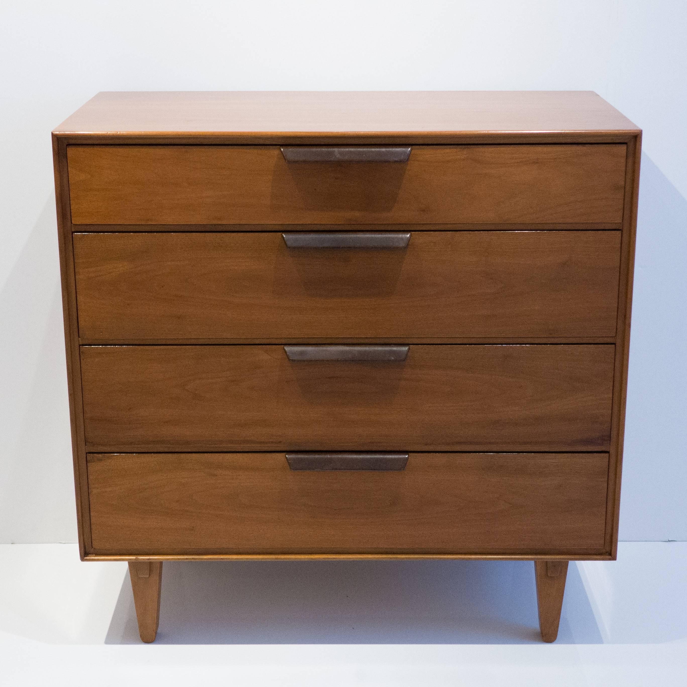 Handsome four drawer chest of drawers in walnut with leather-wrapped pulls. Designed by Edward Wormley for Dunbar Furniture. The superb details evident in this well-crafted piece include book-matched walnut veneer that wraps around the sides and