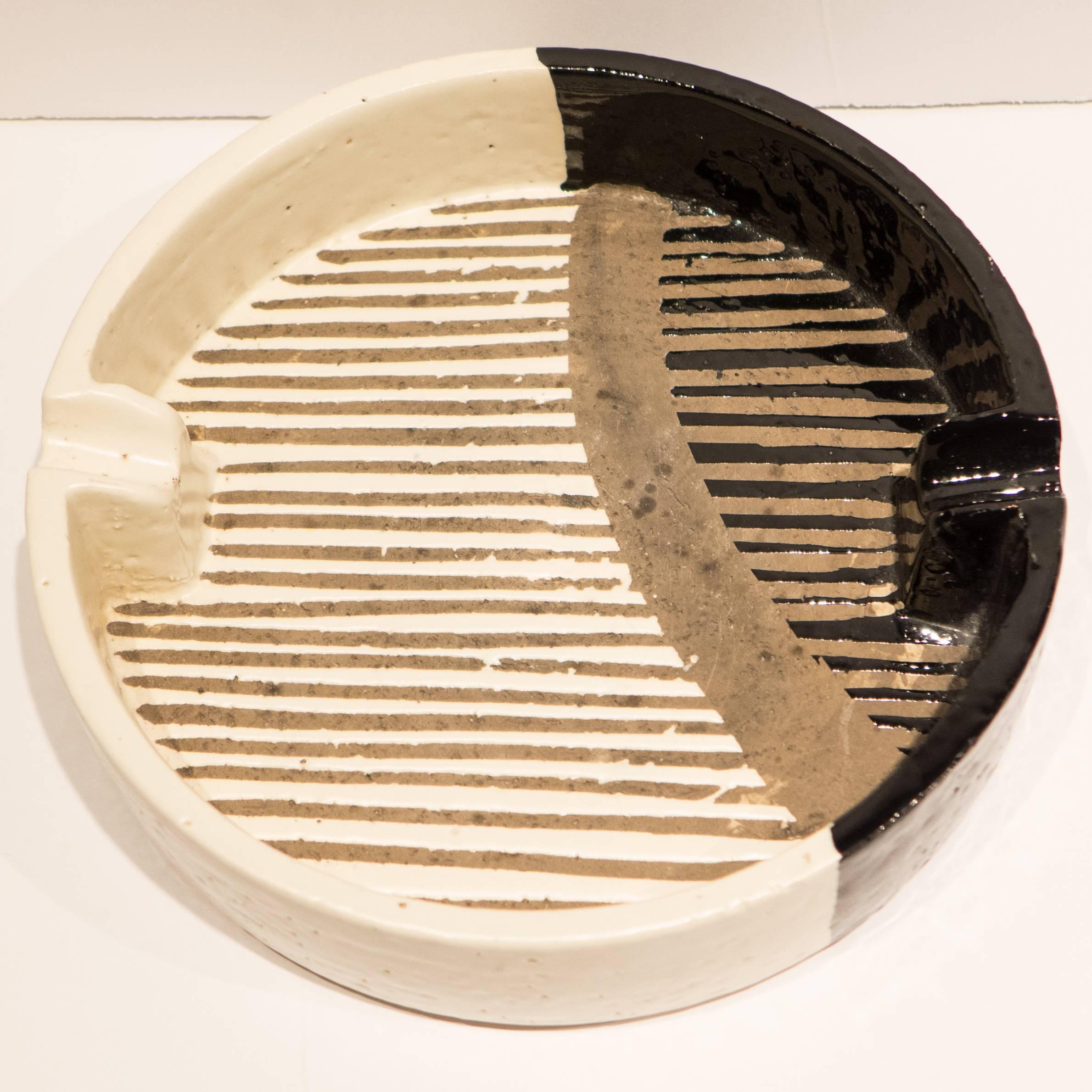 Large dish (or ashtray) with an interesting abstract patterning in black, white, and chamotte. A likely Aldo Londi design, produced by Bitossi for Raymor, circa 1950s. With a Raymor/Bitossi label.