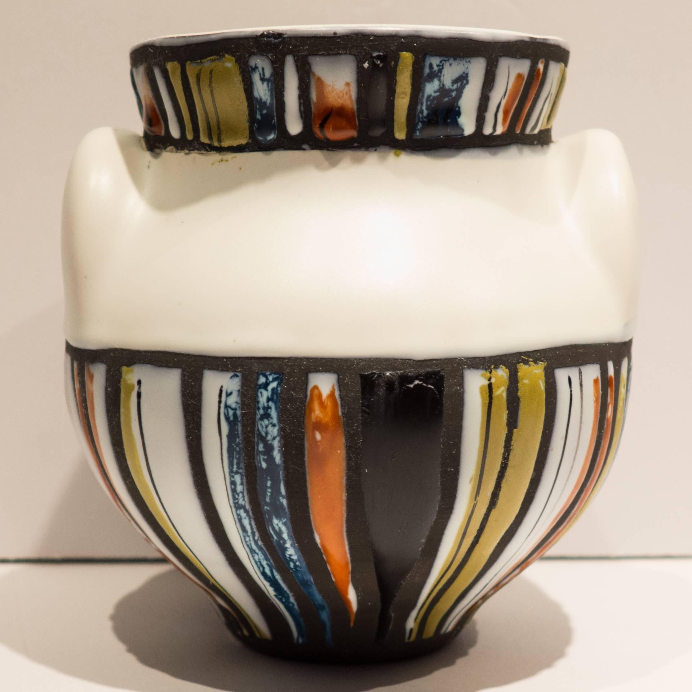 Vase form with ears and applied polychrome enamel paint, by Vallauris master Roger Capron. The smallest of three sizes. Vividly colored and fluidly drawn pattern. With signature to base.