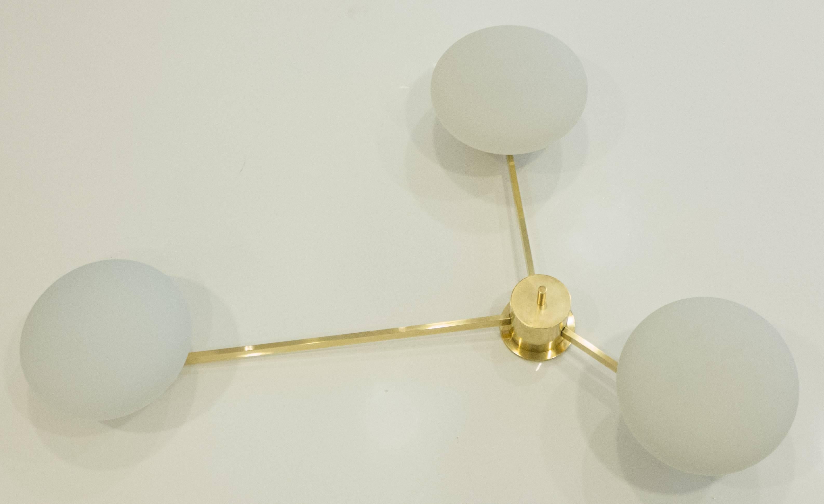 Asymmetrical three-arm ceiling light in brass and chromed metal, with opaline cased glass fixtures. A vintage (circa 1960s) German production attributed to Angelo Lelli for Arredoluce. Stamped Made in Germany on the central column. Flush-mounts to