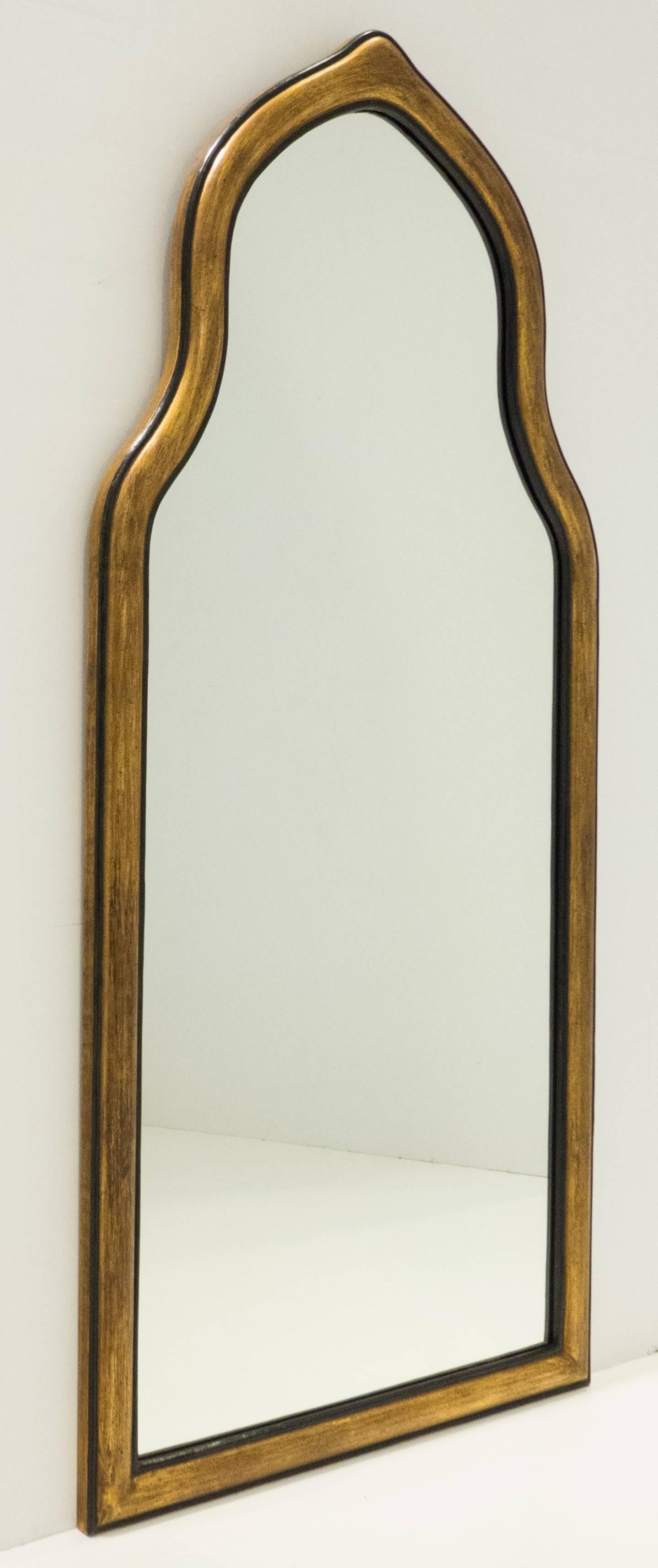 Handcrafted pier or wall mirror with a Moorish arch. Carved wooden frame with patinated gilt gesso and paint. Made by Friedman Brothers, the venerable New York City firm, circa 1950s. 52 inches tall. In excellent condition, still with the original