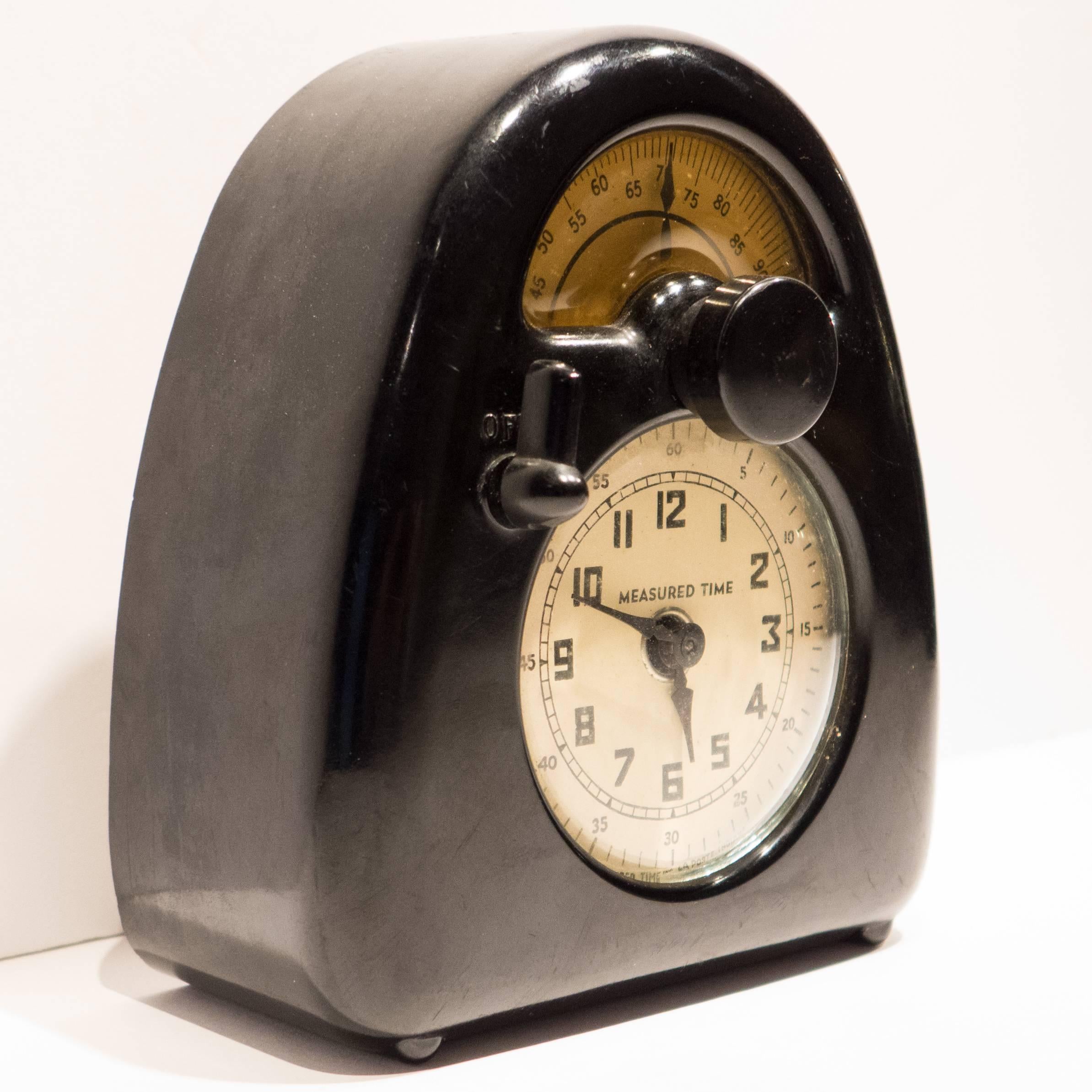 Measured time clock of bakelite, glass, metal, plastic, and printed paper, produced by the Stevenson Mfg Co, c. 1932. A wind-up model in fine original condition. An Isamu Noguchi Machine Age design verified by the Noguchi Foundation in 2014.