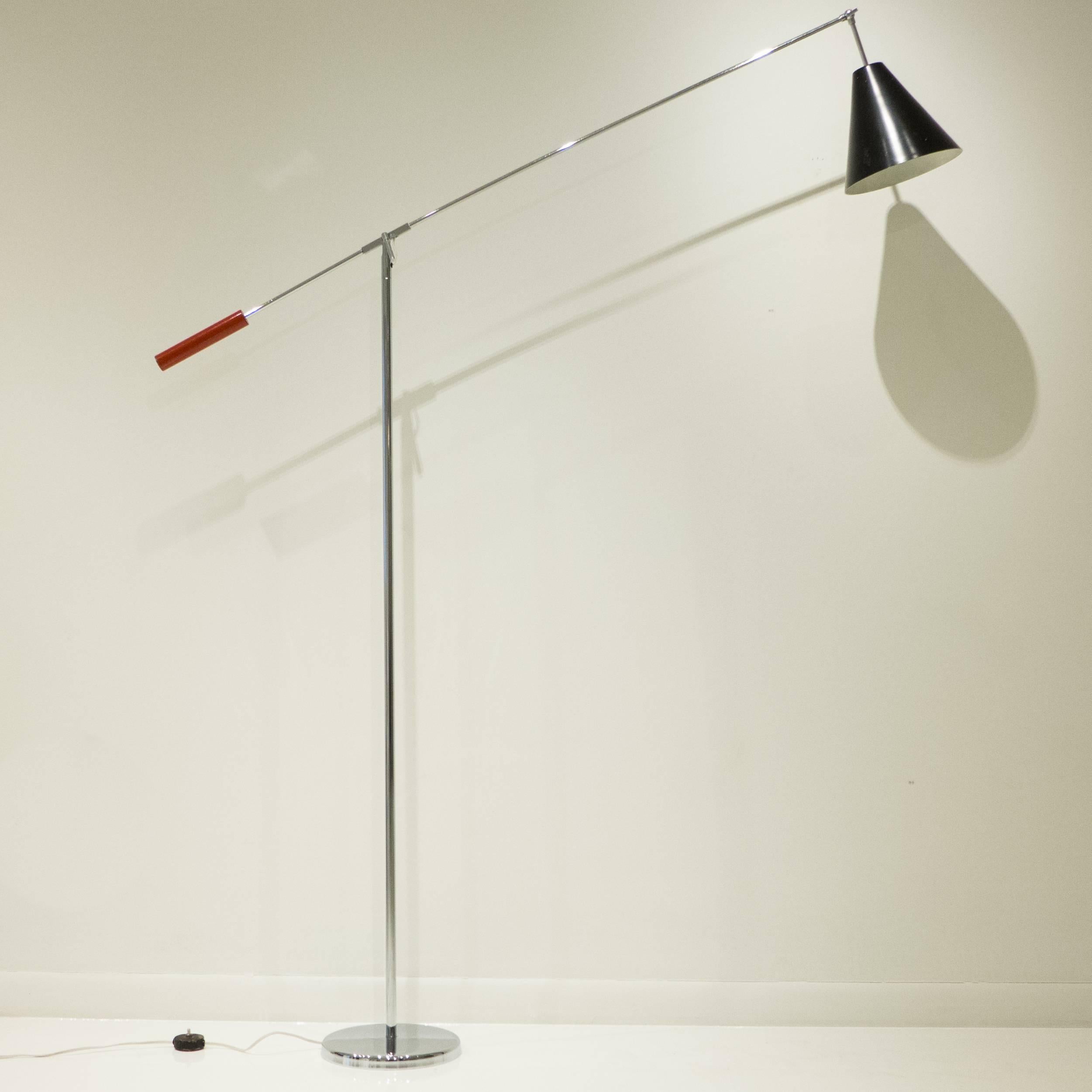 Single-arm, adjustable floor lamp of steel and chromed tubular steel, with lacquered black and red accents on the conical visor and counterweight, respectively. A Minimalist version of the iconic Triennale lamp, with a wingspan of 59