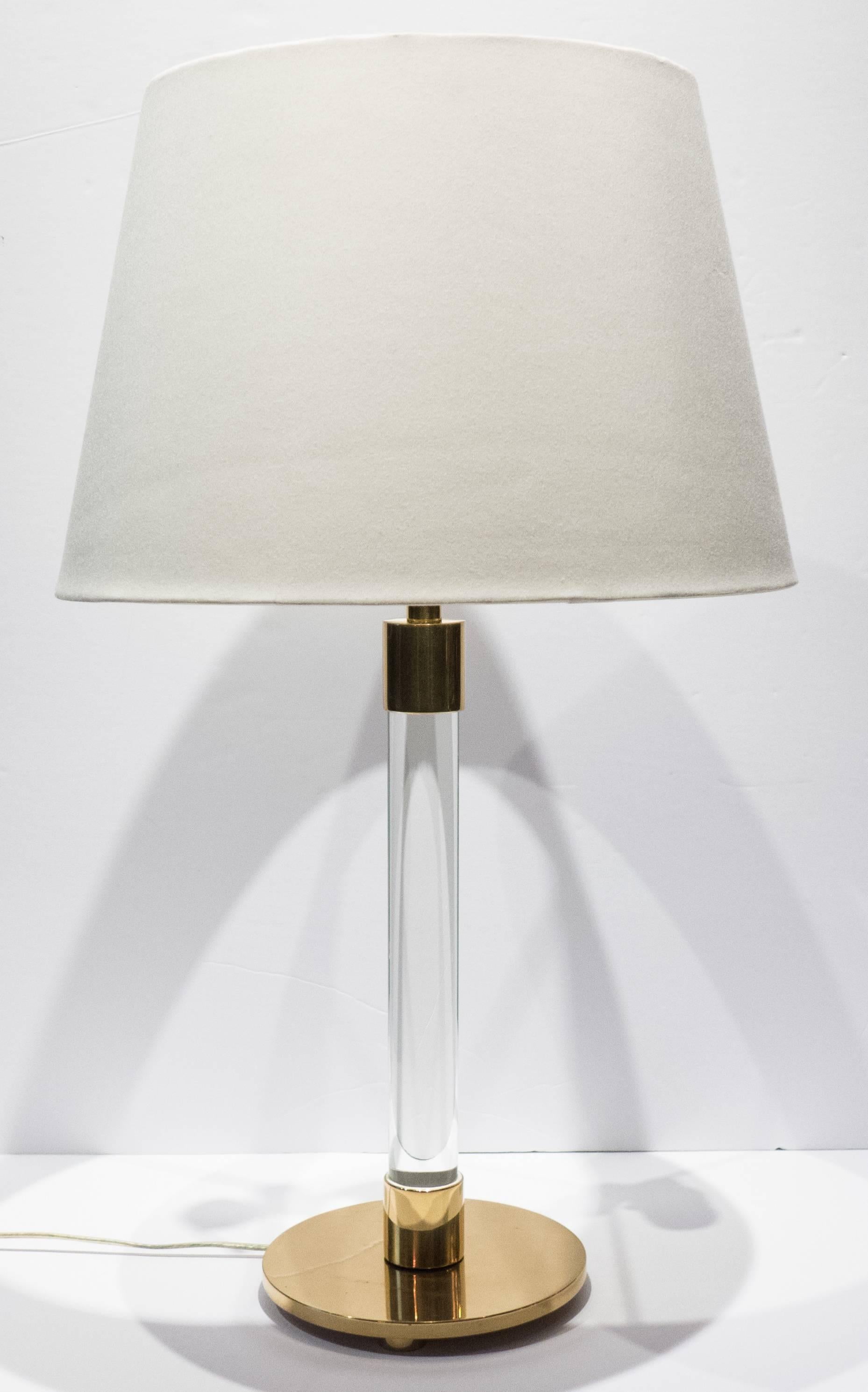Hansen table lamp with uncommon (footed) round base, along with glass rod and well-machined brass fittings. A Minimalist and elegant design, scarcely seen in a table version. The cord is inset into a channel in the rear of the glass rod, and is