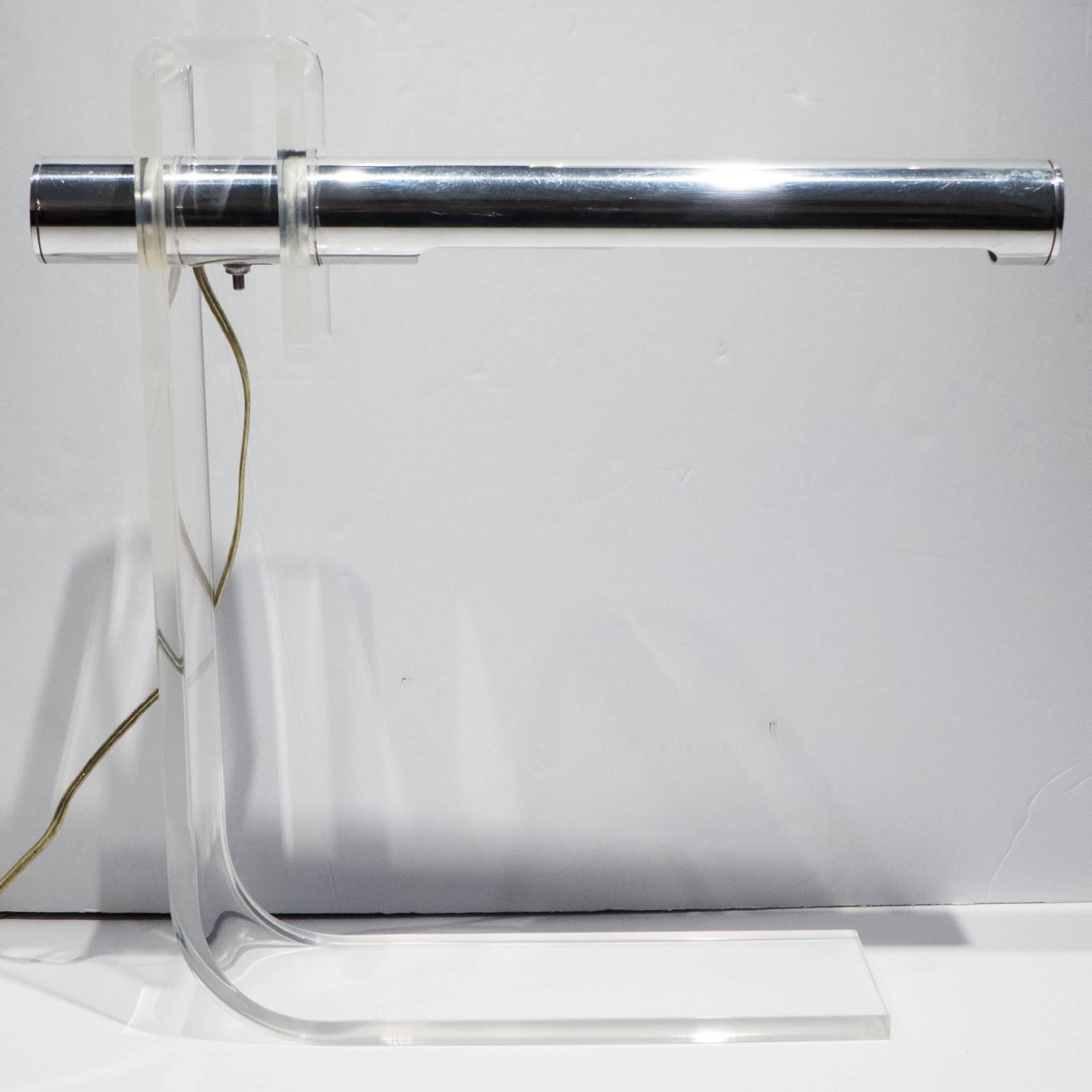 Table lamp of clear acrylic with a pivoting tubular aluminum visor. A spare and stylish, circa 1970 design produced by Robert Sonneman. In excellent condition with no chips, cracks, or discoloration to the acrylic and only very minor wear overall