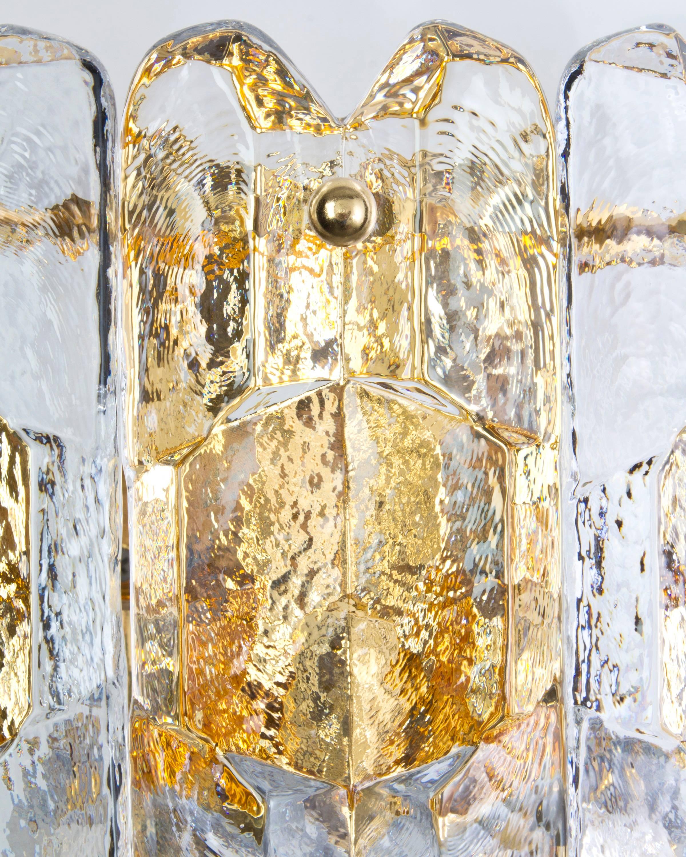 AIS2932.

A pair of vintage sconces having gilded metalwork dressed with ice style prisms. Signed by the Austrian glassmaker Kalmar. Due to the antique nature of this fixture, there may be some nicks or imperfections in the glass as well as