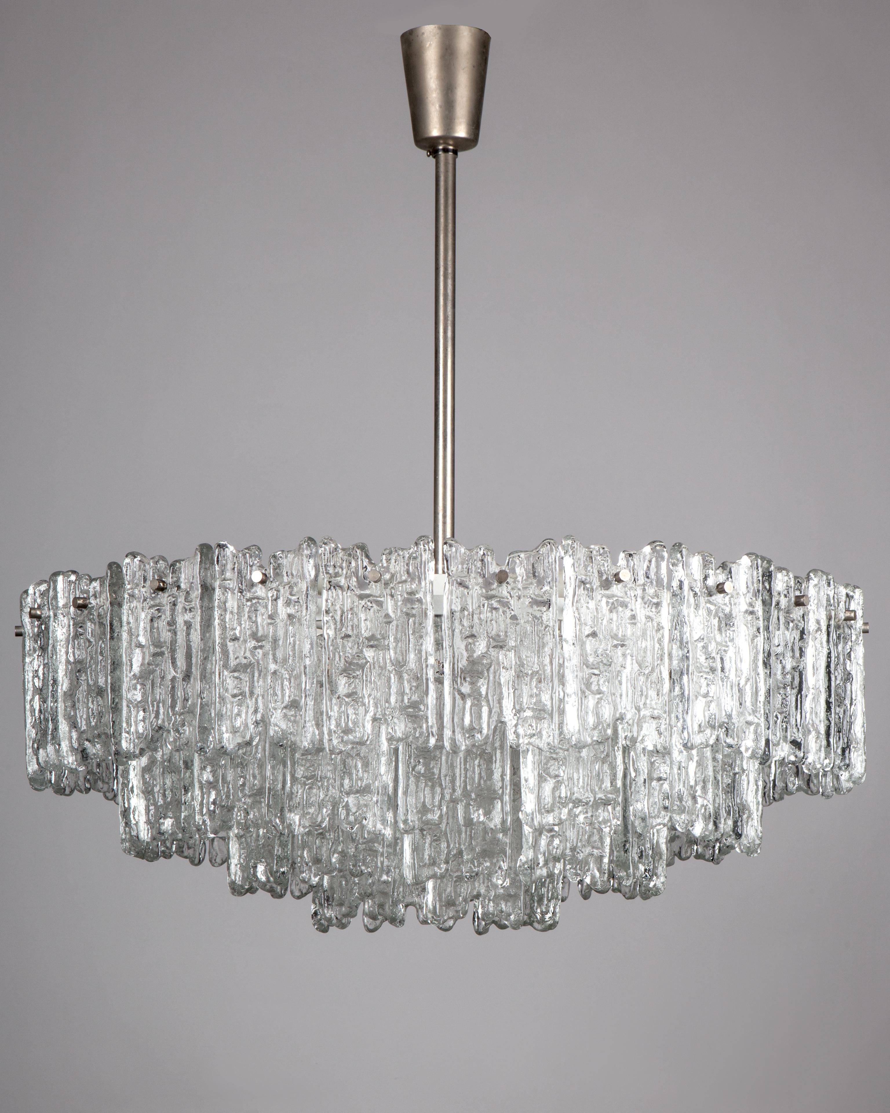 AHL3951
A large vintage chandelier with deeply textured glass tiles and aged nickel metalwork designed by the Austrian maker Kalmar. Due to the antique nature of this fixture, there may be some nicks or imperfections in the