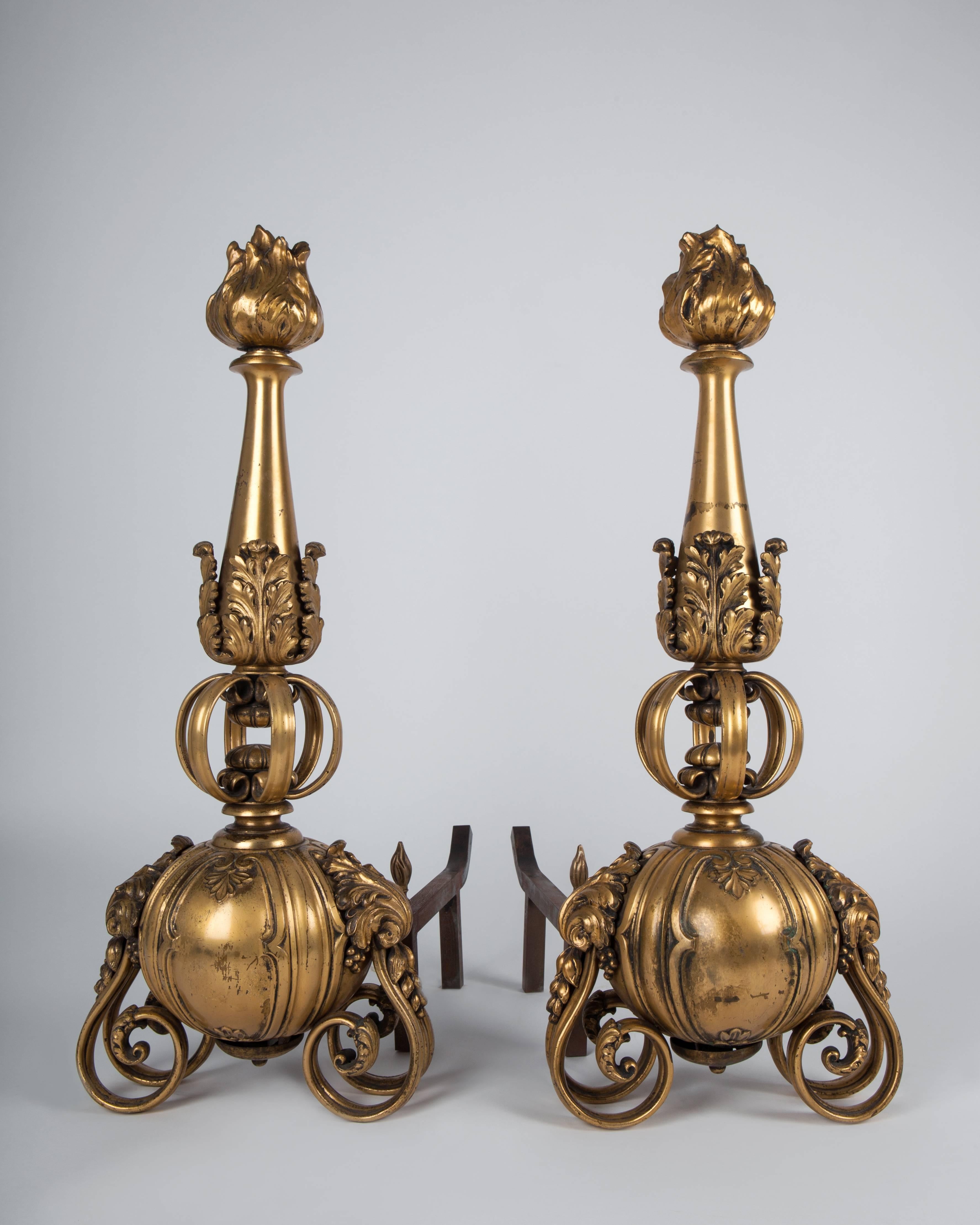 AFP0514
A pair of gilded bronze andirons supported on foliate form double S scrolls. The torch finials are held over the bases on a basket of C curves. Likely by the New York maker Sterling Bronze Co.

Dimensions:
Overall: 27