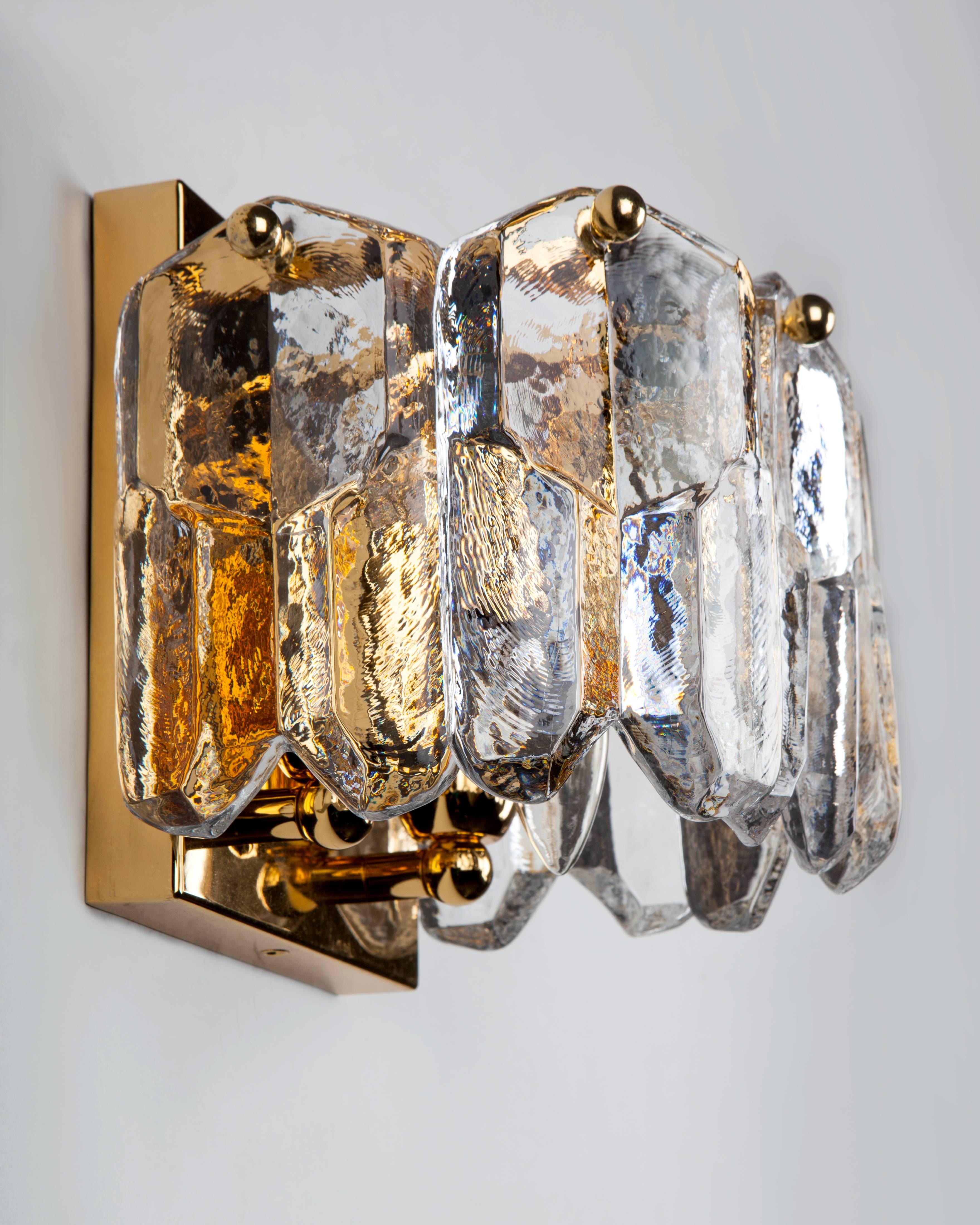 AIS2974
A pair of vintage sconces with thick cast glass ice style crystal prisms held on gilded metal frames. Signed by the Austrian maker Kalmar. Due to the antique nature of this fixture, there may be some nicks or imperfections in the