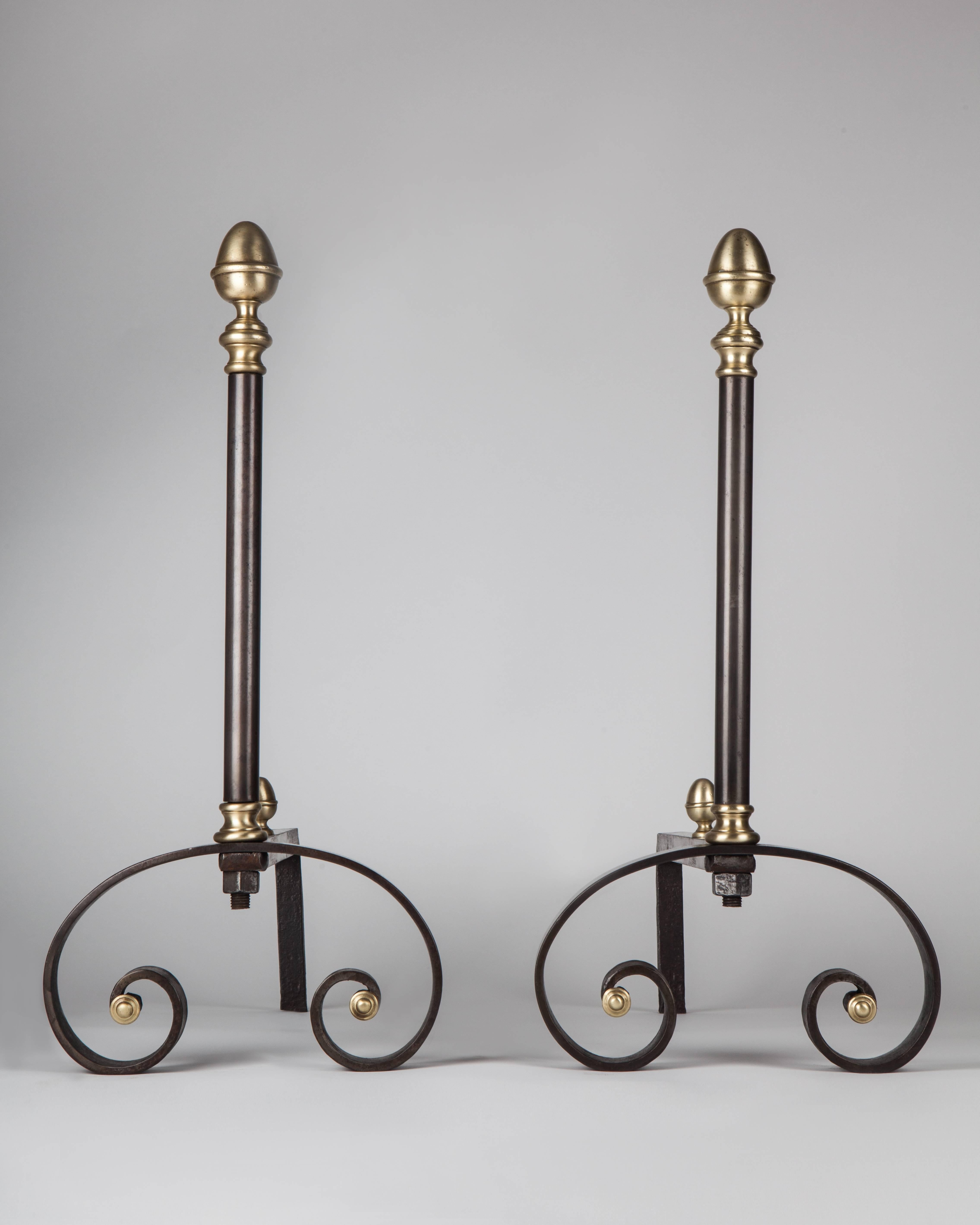 AFP0541,

A pair of wrought iron and brass andirons with a wonderful, strong graphic design of large scrolled feet and tall shafts topped with brass acorn finials.

Dimensions:
Overall: 23 1/2