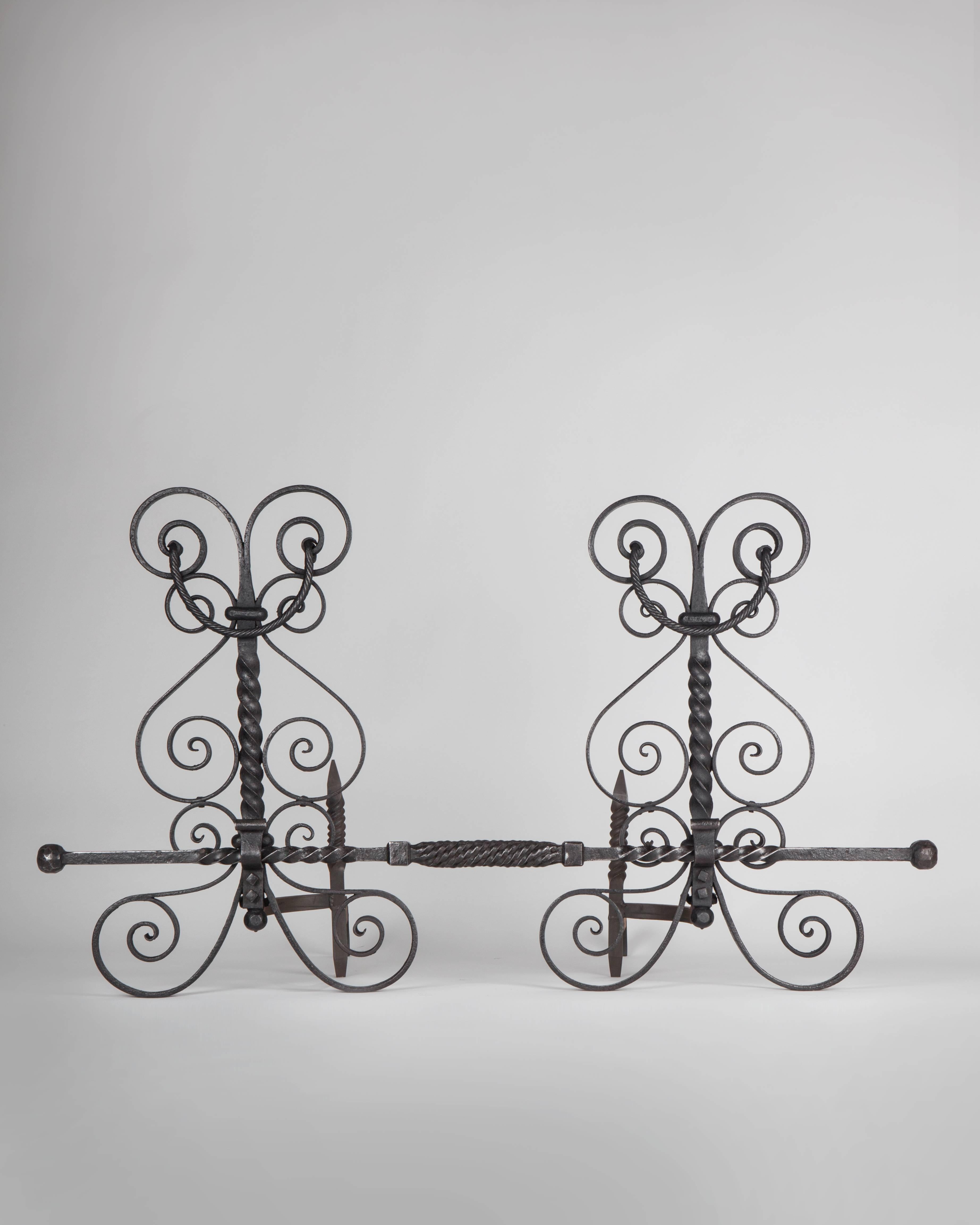 AFP0545
A pair of antique wrought iron andirons with elaborate scroll and twist details, complete with an original fender crossbar.

Dimensions:
Overall: 25