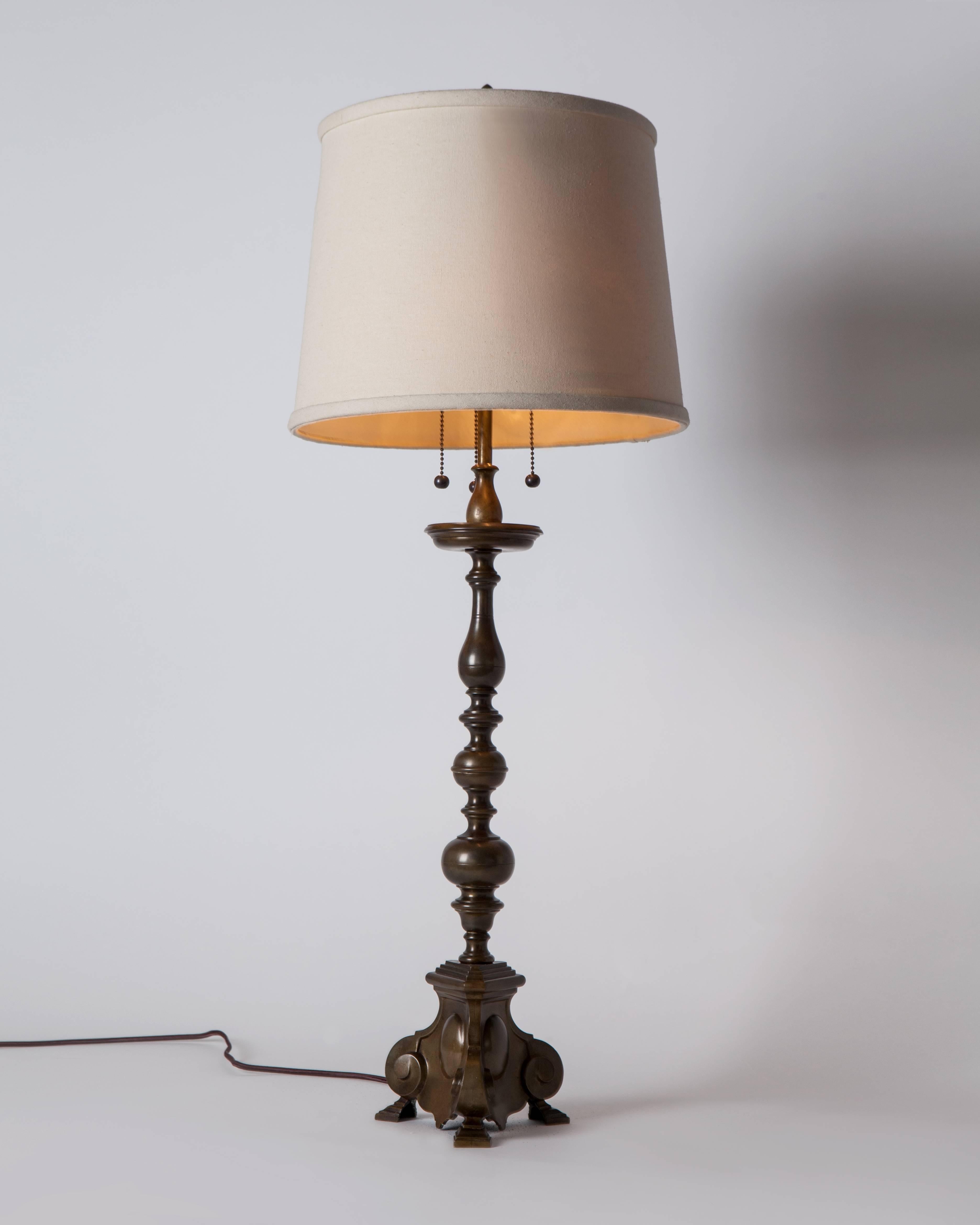 ATL1938
An antique bronze table lamp with a baluster-form standard above a baroque tripod base, in its original, wonderful, age-darkened, variegated patina. Having the original lamp bodies, socket shells, and finials. Attributed to the New York
