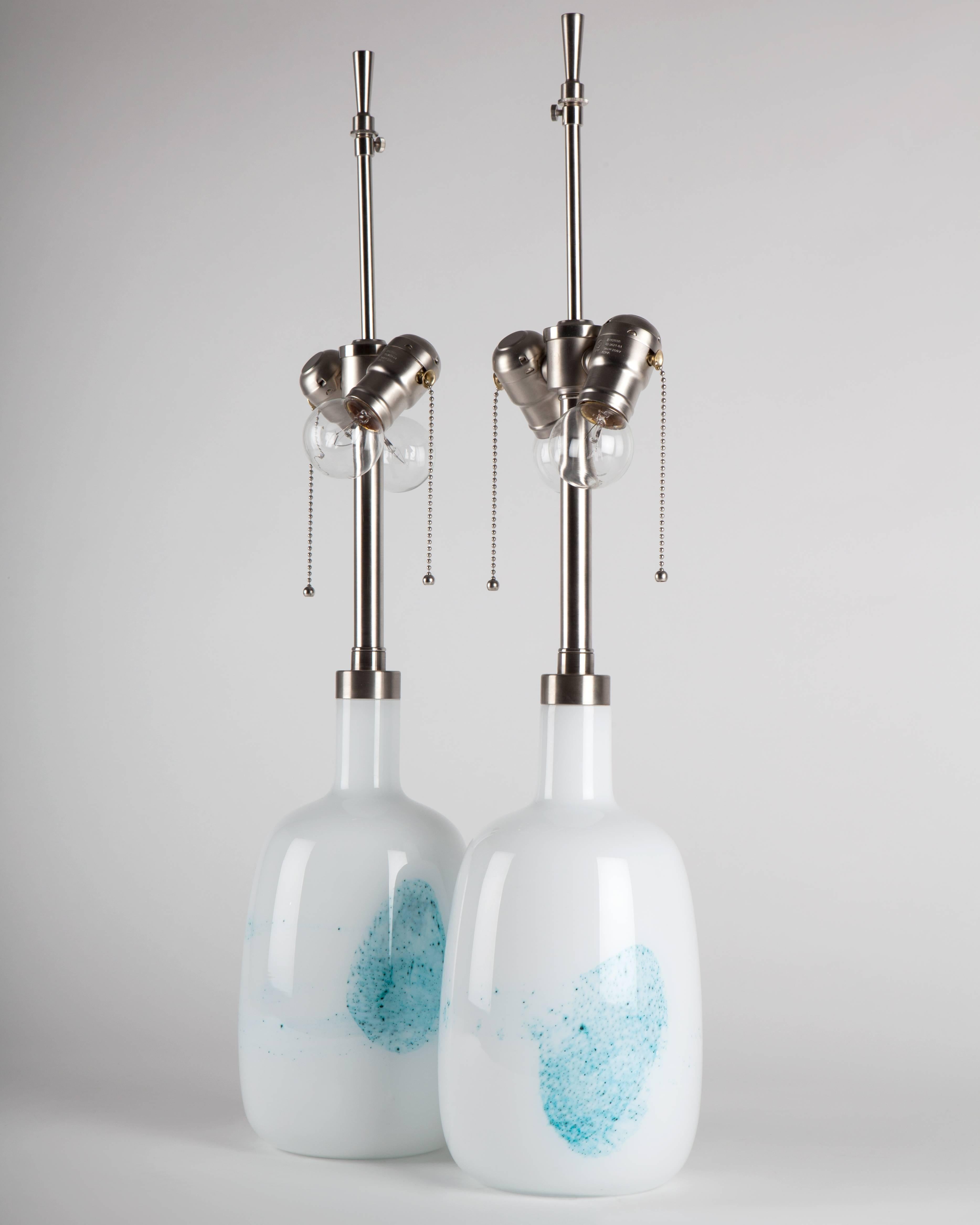 ATL1934,

a pair of vintage blue and white glass table lamps with brushed nickel fittings. Signed by the Danish maker Le Klint. Due to the antique nature of this fixture, there may be some nicks or imperfections in the glass as well as variations