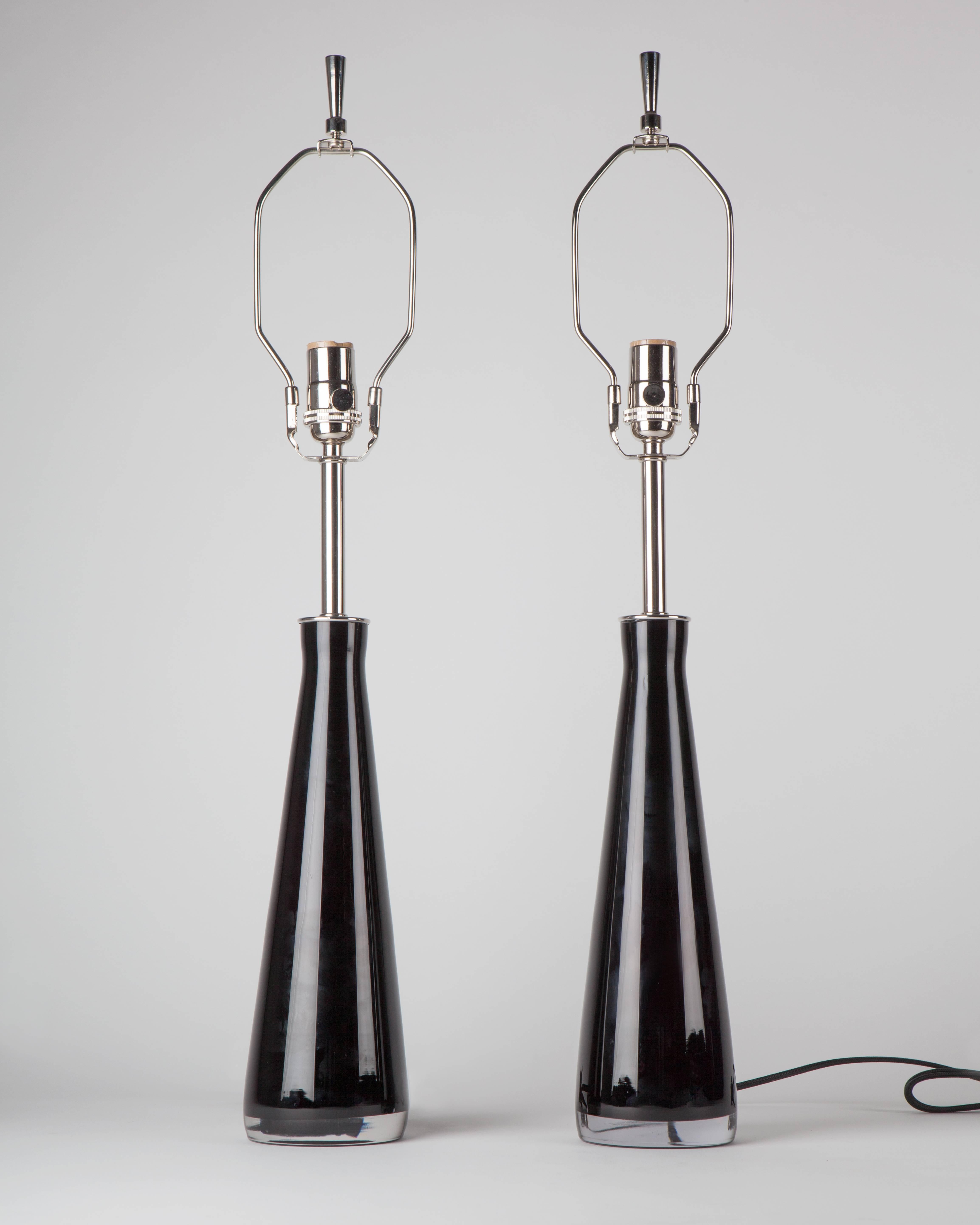 ATL1941.
A pair of dark purple cased glass lamps with nickel fittings signed by the Swedish maker Falkenbergs Belysning. Due to the antique nature of this fixture, there may be some nicks or imperfections in the glass.

Dimensions:
Overall: 27