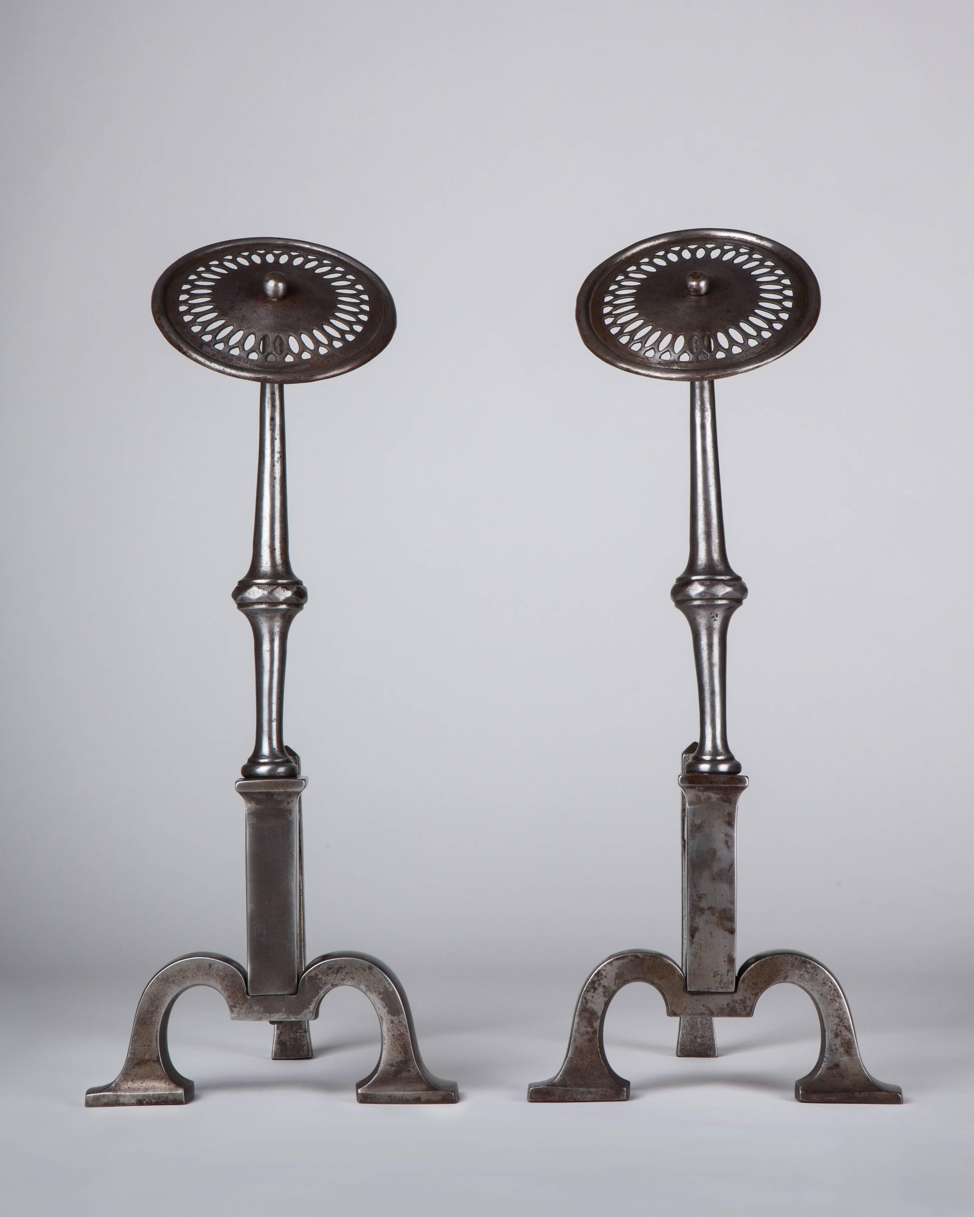 AFP0552
A pair of wrought iron andirons with flat pierced circular finials and forged bodies.

Dimensions:
Overall: 17