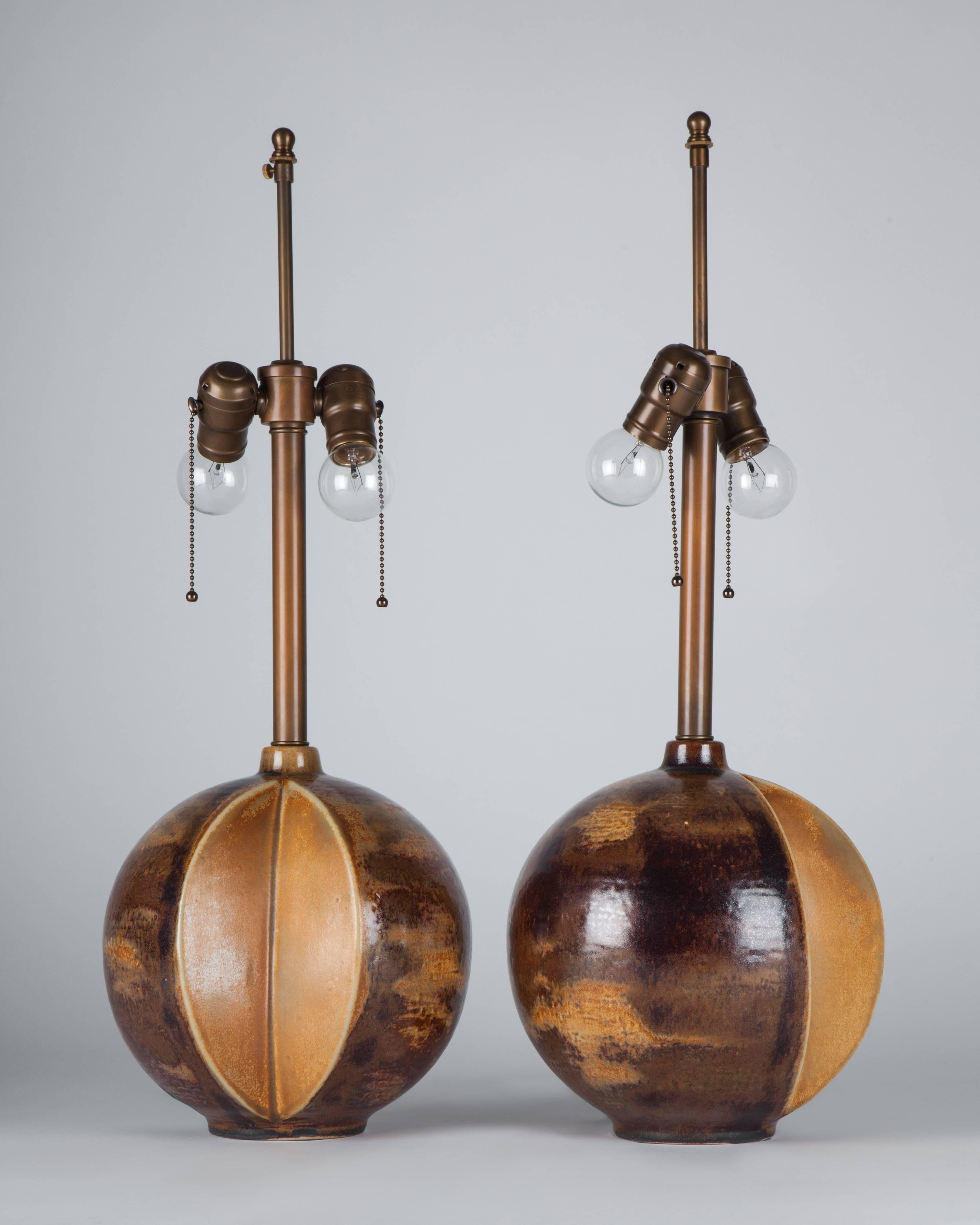 ATL1946
A pair of peri-spherical ceramic lamps having rich, variegated surfaces with iron and rutile bearing glazes. Signed by the Danish maker Soholm Stentoj. Due to the antique nature of these fixtures, there may be some nicks or imperfections in