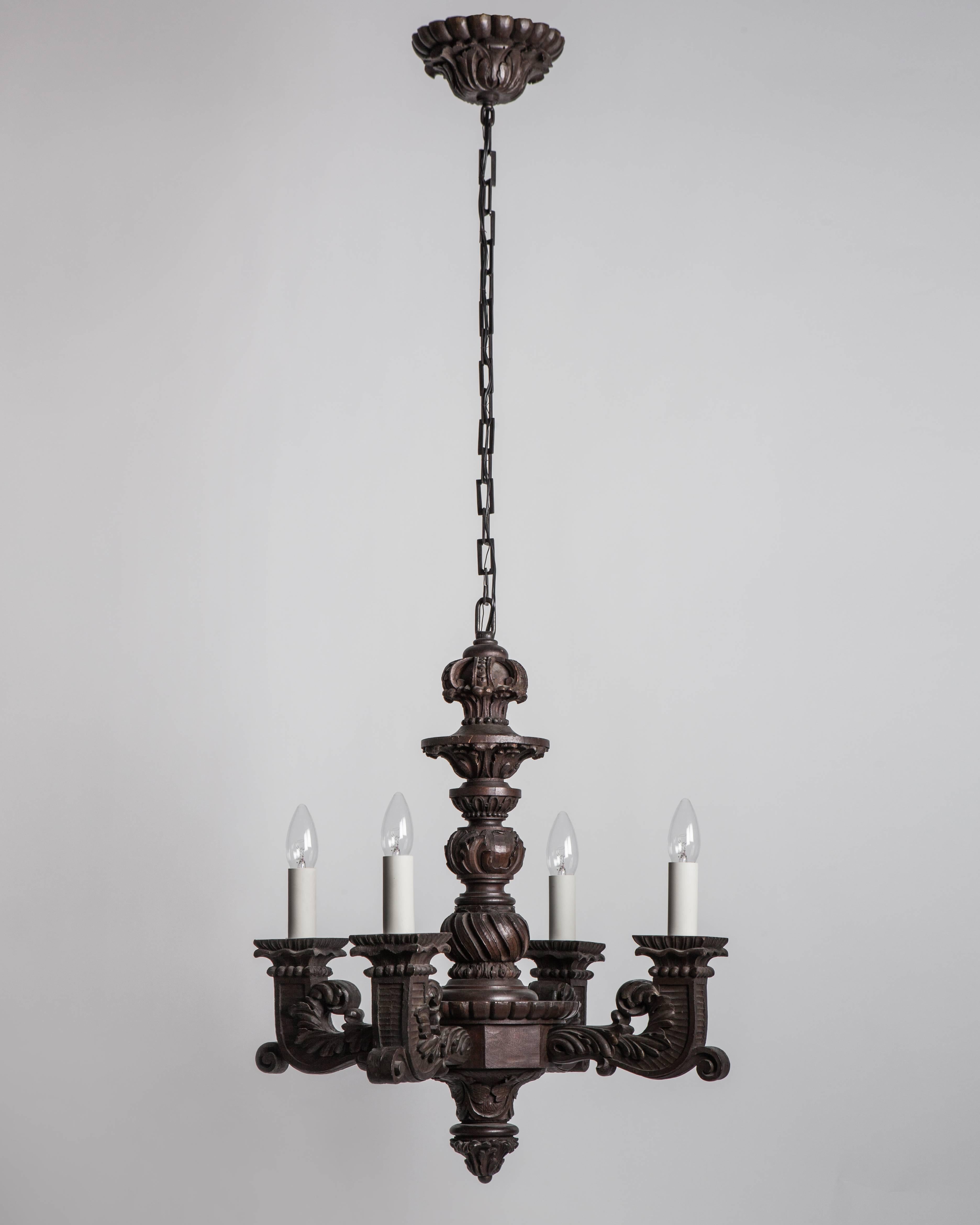 AHL2961
A solid and crisply carved dark wooden four-light chandelier. Having foliate carvings overall and accented by faceted prism pendants. From a Hudson River estate in Athens, NY.

Dimensions:
Current height 57-1/2