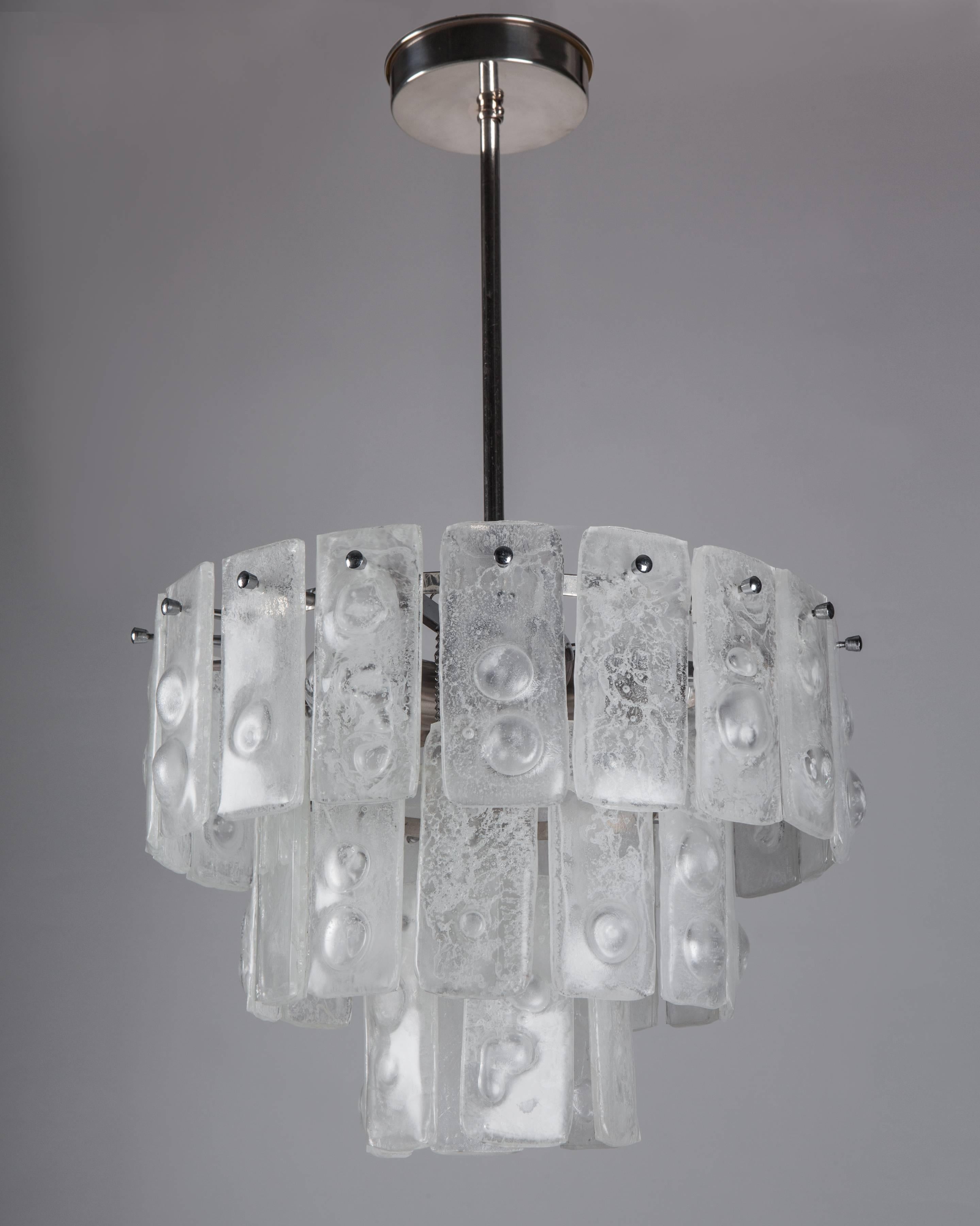AHL4051

A three-tier vintage modernist chandelier having a chrome, nickel and silver plate frame dressed with handblown and formed seeded, bubbled glass tiles. Due to the antique nature of this fixture, there may be some nicks or imperfections in