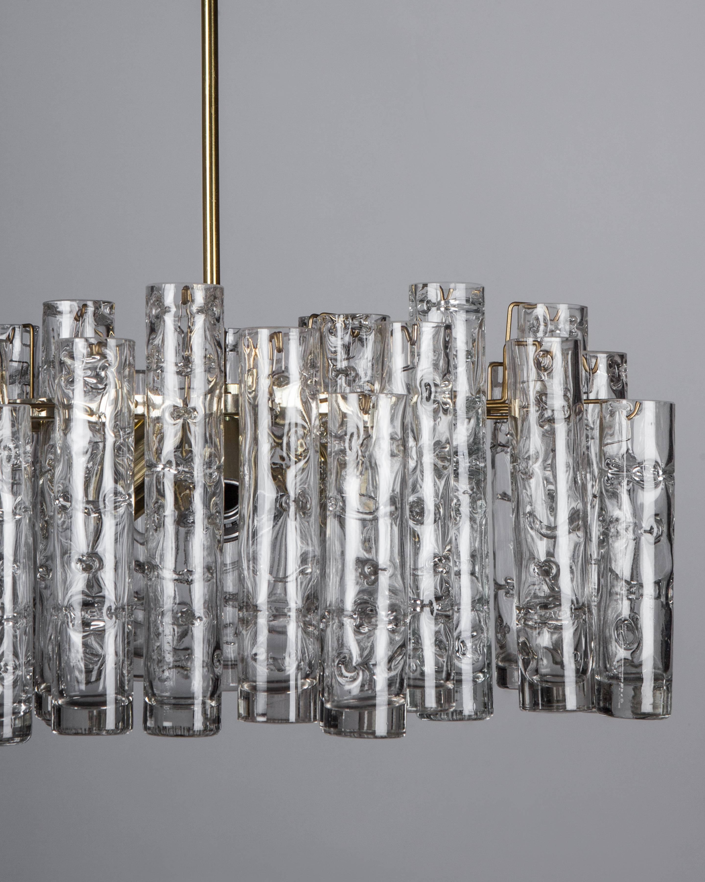AHL4052
A vintage chandelier with textured blown glass tube prisms staggered on a frame in its original aluminum and aged brass finish. Signed by the German maker Doria. Due to the antique nature of this fixture, there may be some nicks or