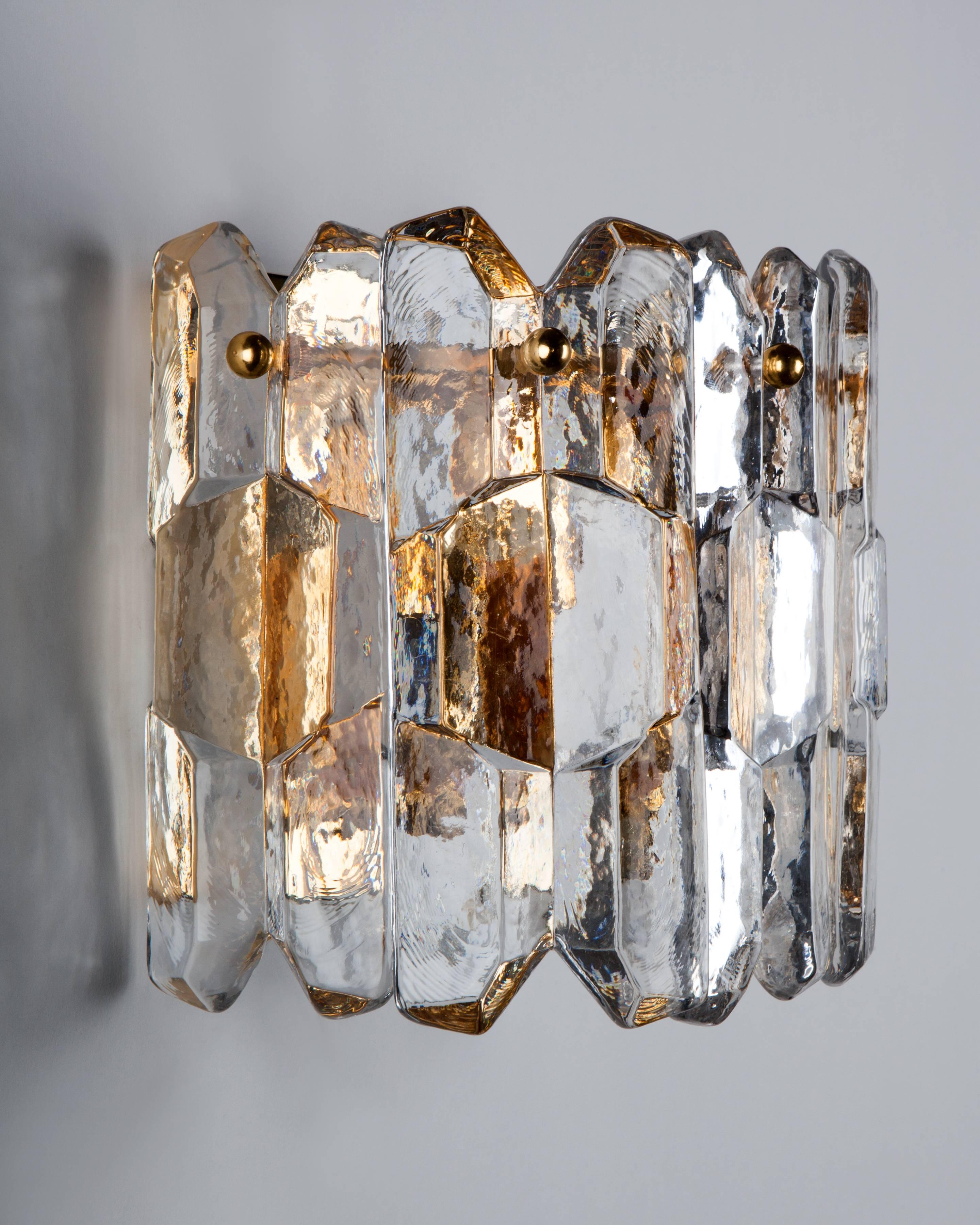 AIS3006

A vintage sconce with five thick cast glass ice style prisms held on a gilded metal frame. Designed by the Austrian maker Kalmar. Due to the antique nature of this fixture, there may be some nicks or imperfections in the glass as well as