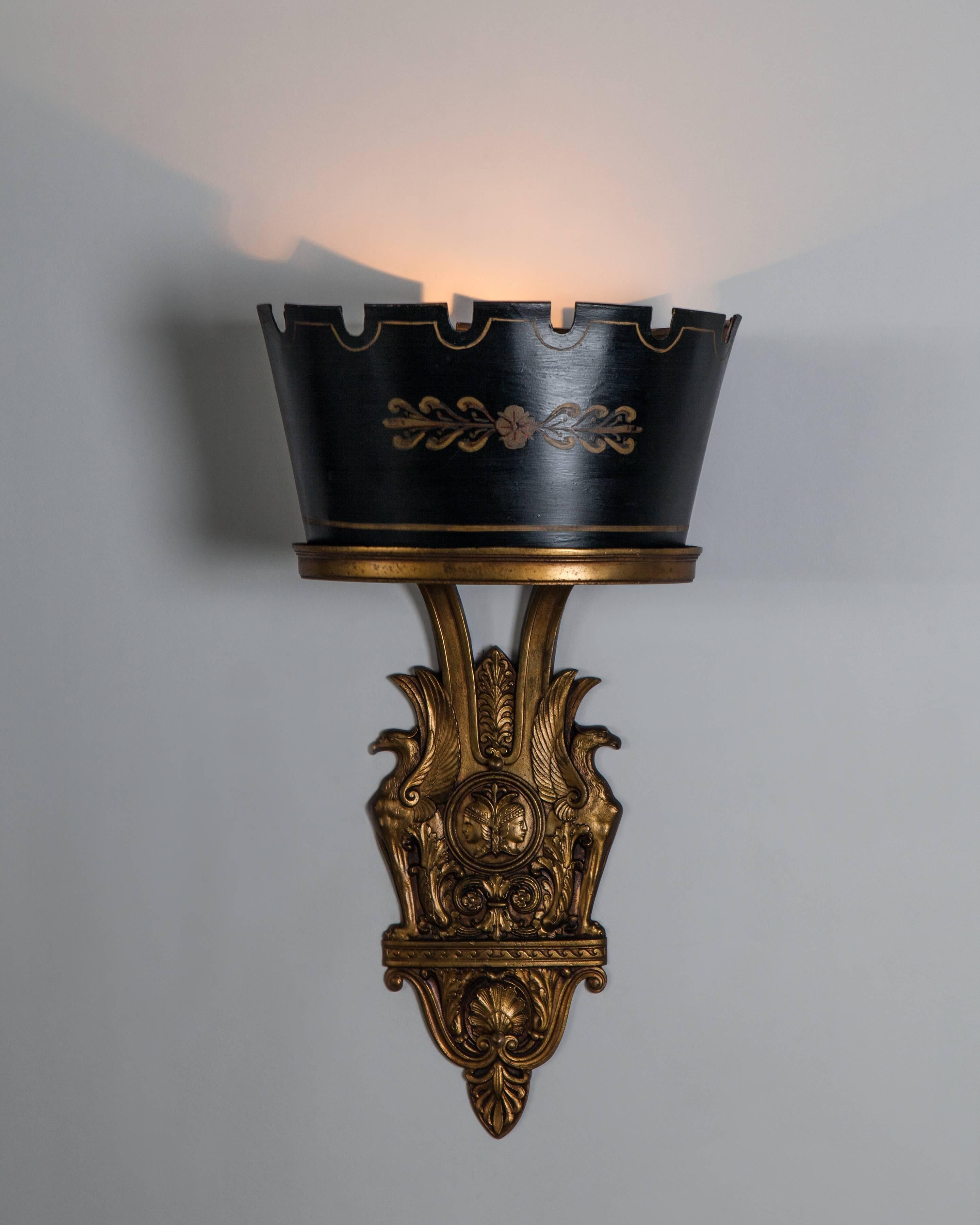 AIS3012
A pair of aged brass Empire wall sconces with toleware shades in their original hand-painted finish. Signed by the New York maker Sterling Bronze Co.
