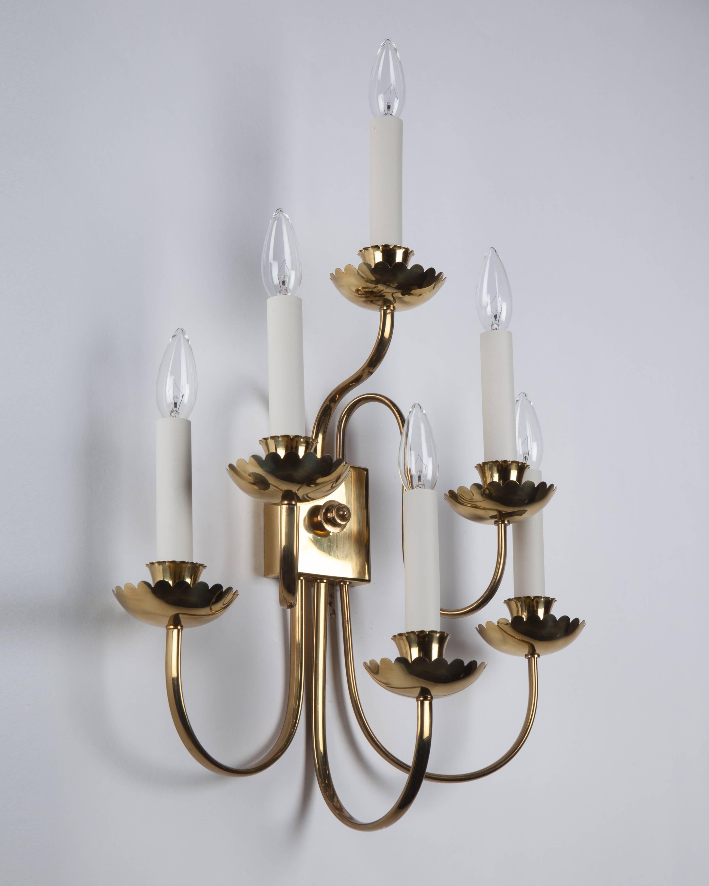 AIS3013
A pair of six-light Mid-Century sconces with sleek S-curving arms and scalloped-edge cups and bobeches in their original lacquered brass finish. Bearing Italian export stamps.
 