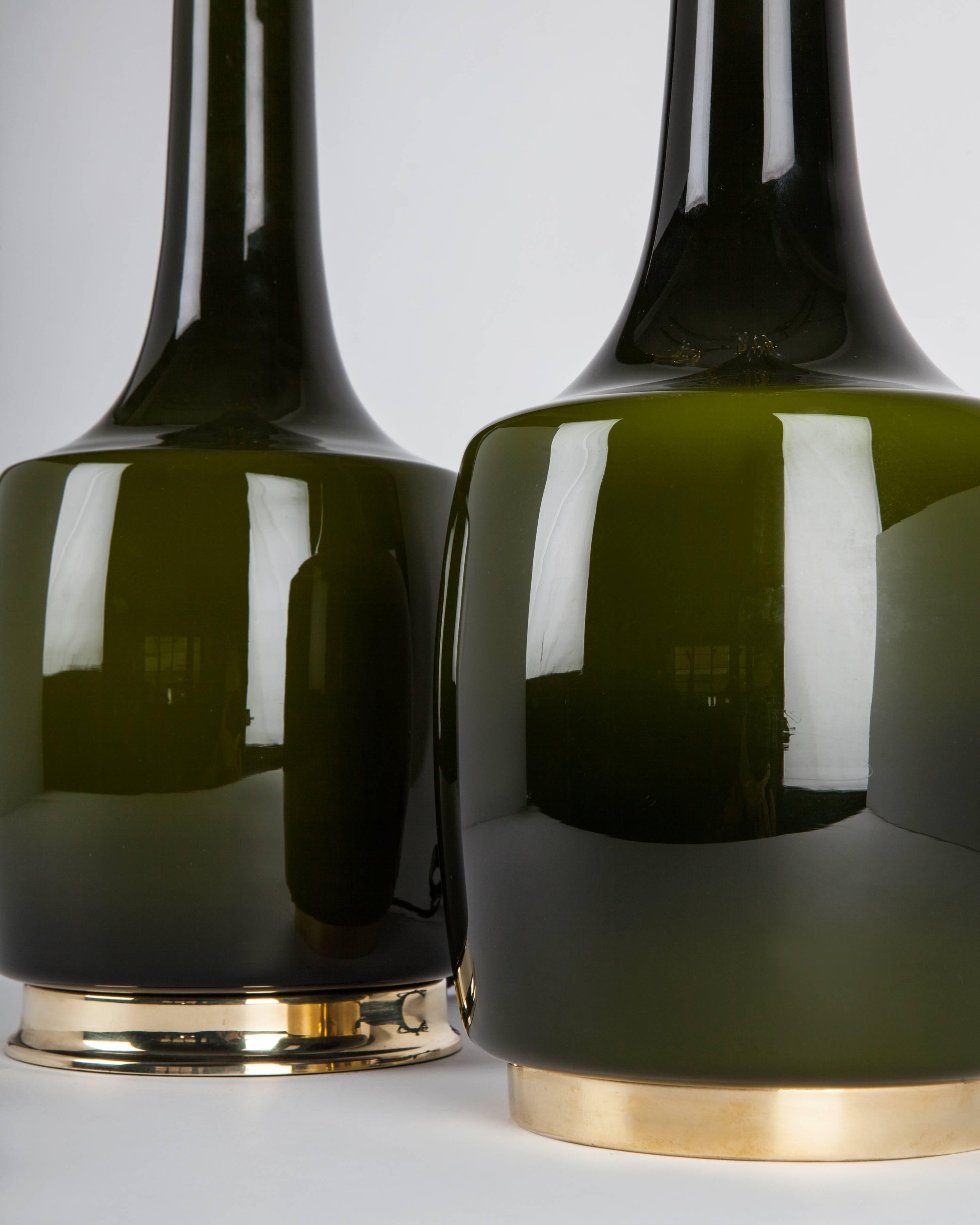 ATL1955
A pair of tall vintage green cased glass table lamps having polished brass fittings. Signed by the Swedish maker Bergboms, the glass bearing Holmegaard's Danish export stamp. Due to the antique nature of these fixtures there are nicks and